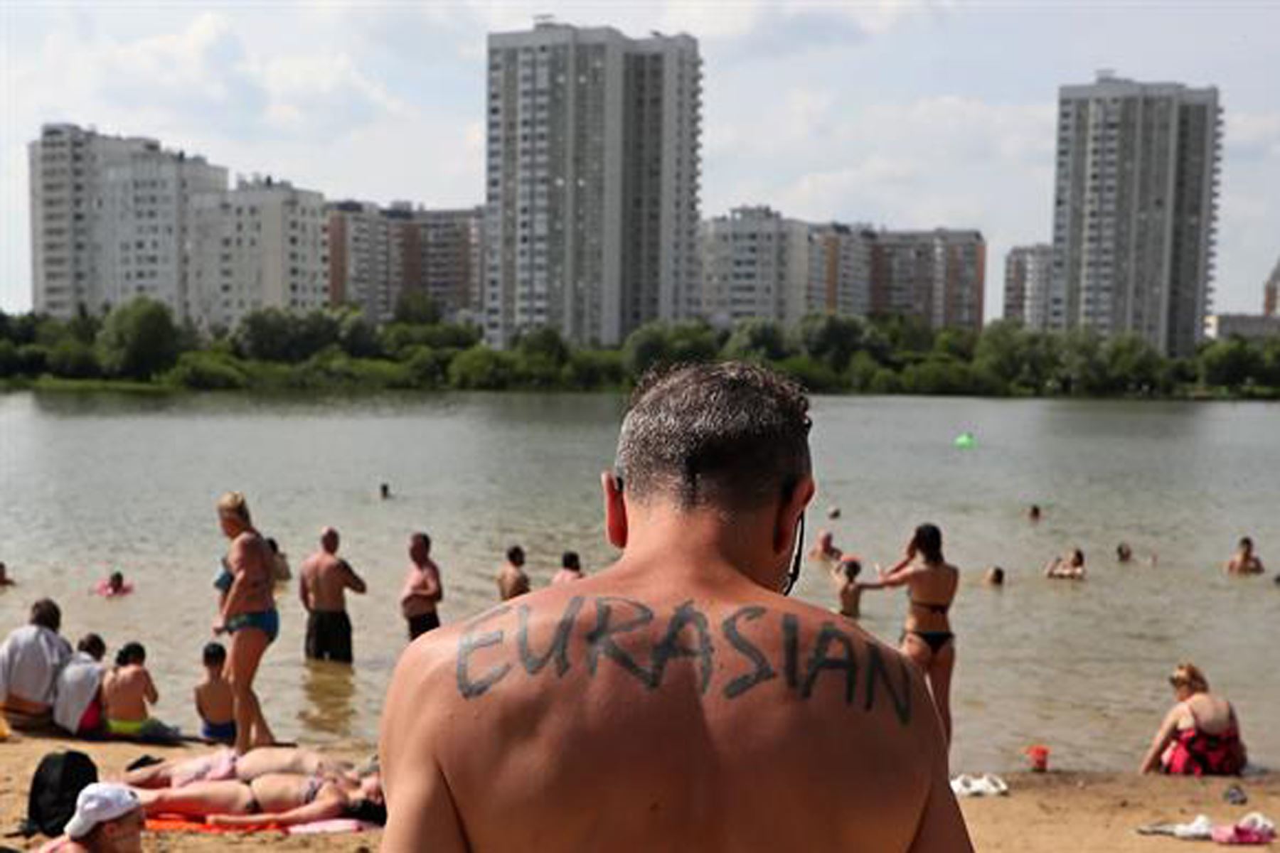 La gente disfruta de un día caluroso en un estanque en un distrito residencial de Moscú, Rusia. La temperatura en Moscú superó los 31 grados Celsius. 
Foto: EFE