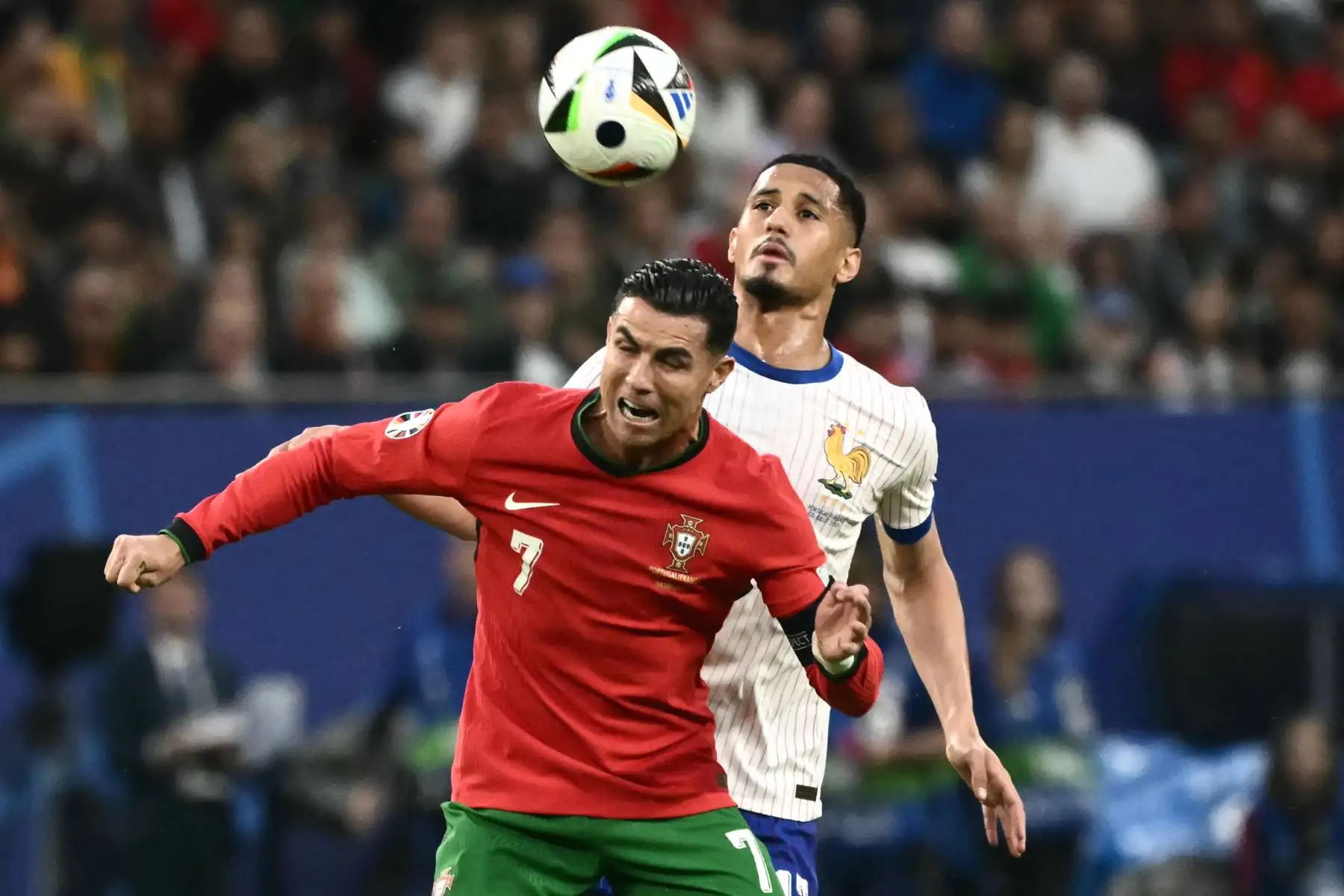 El delantero de Portugal Cristiano Ronaldo salta al balón con el defensor de Francia William Saliba durante el partido de fútbol de cuartos de final de la UEFA Euro 2024 entre Portugal y Francia. Foto: ANDINA/AFP
