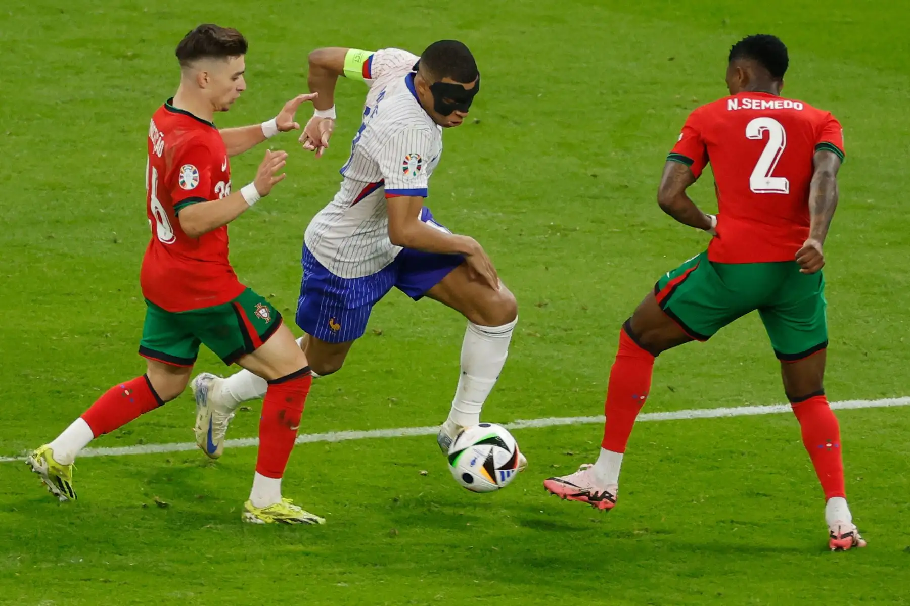 El delantero francés  Kylian Mbappe lucha por el balón con el delantero portugués Francisco Conceicao y el defensor portugués Nelson Semedo durante el partido de fútbol de cuartos de final de la UEFA Euro 2024 entre Portugal y Francia. Foto: ANDINA/AFP