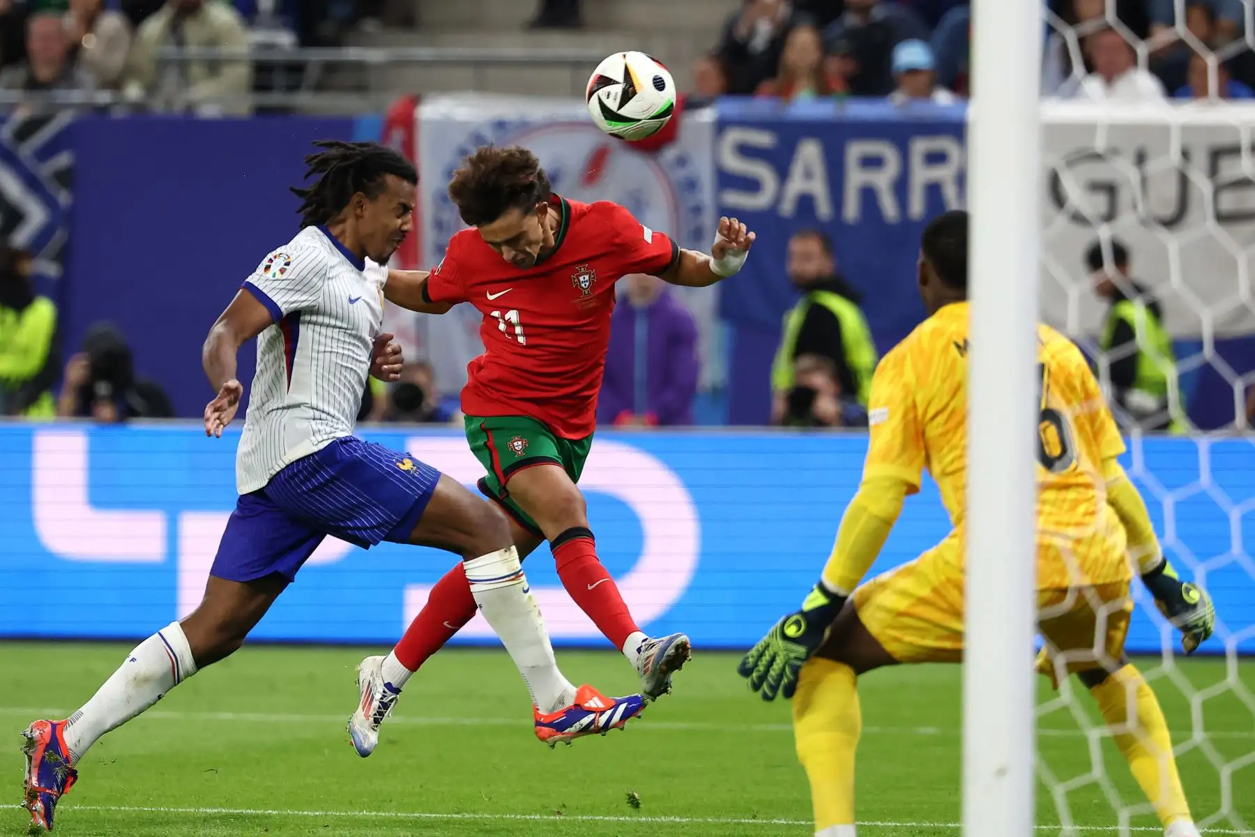 El delantero portugués Joao Felix encabeza el balón en un intento de gol contra el defensor francés Jules Kounde  durante el partido de fútbol de cuartos de final de la UEFA Euro 2024 entre Portugal y Francia.Foto: ANDINA/AFP