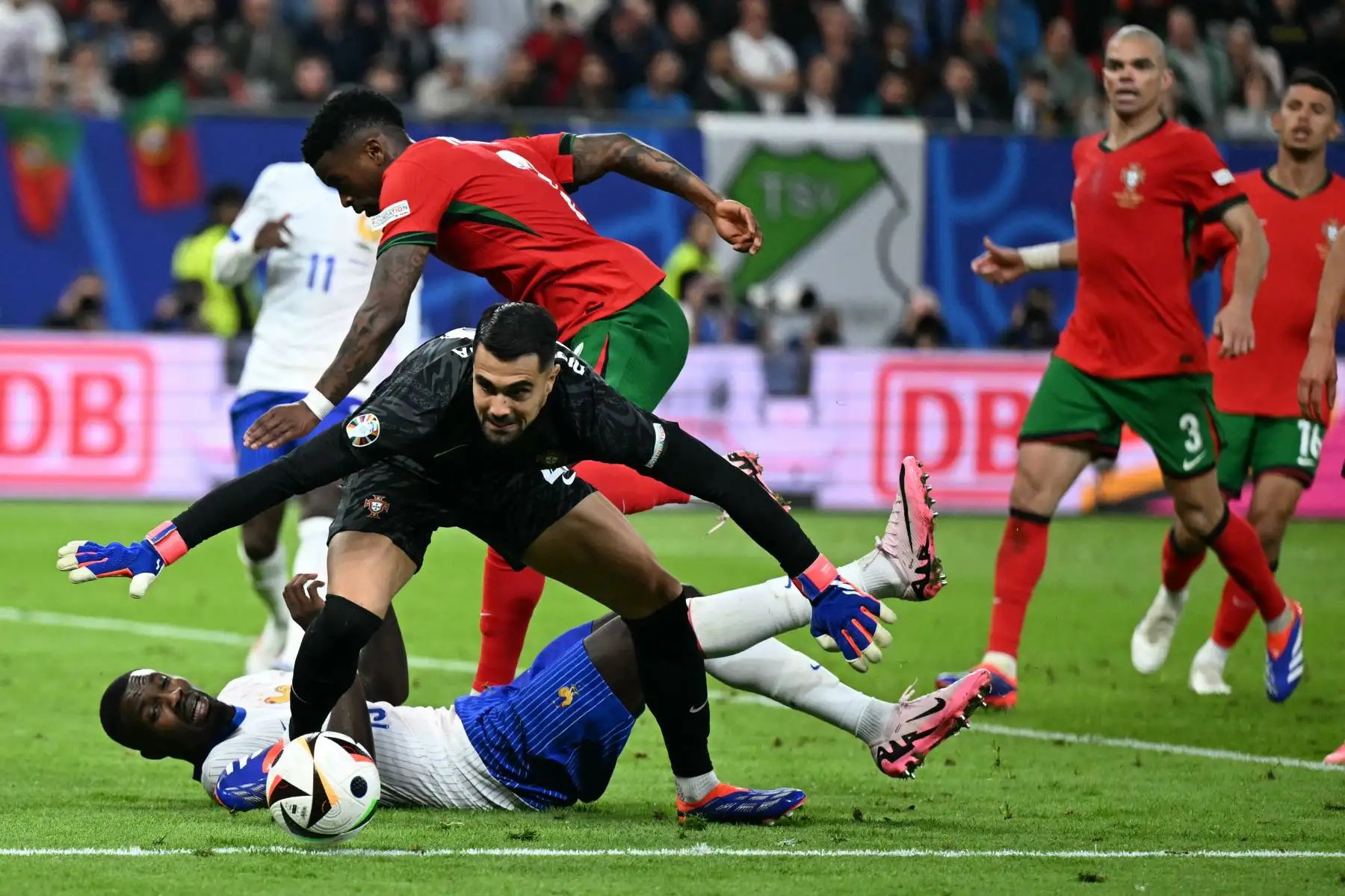 El portero portugués  Diogo Costa salva el balón frente al delantero francés Marcus Thuram durante el partido de fútbol de cuartos de final de la UEFA Euro 2024 entre Portugal y Francia. Foto: ANDINA/AFP
