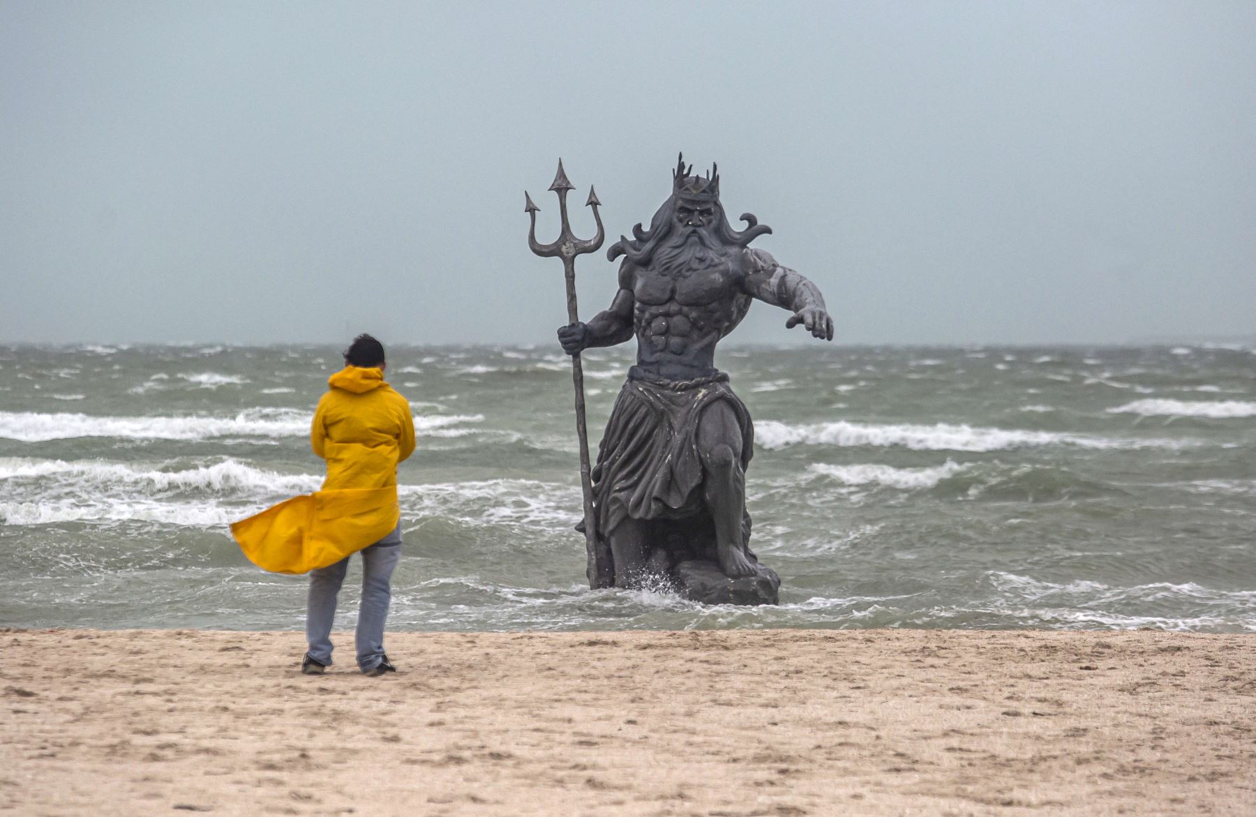 Un hombre mira una estatua del dios griego Poseidón en una playa durante el paso de la tormenta tropical Beryl en Progreso, en la Península de Yucatán, México, el 5 de julio de 2024. Beryl se debilitó a tormenta tropical el viernes después de golpear a México como categoría. 2 huracanes. AFP