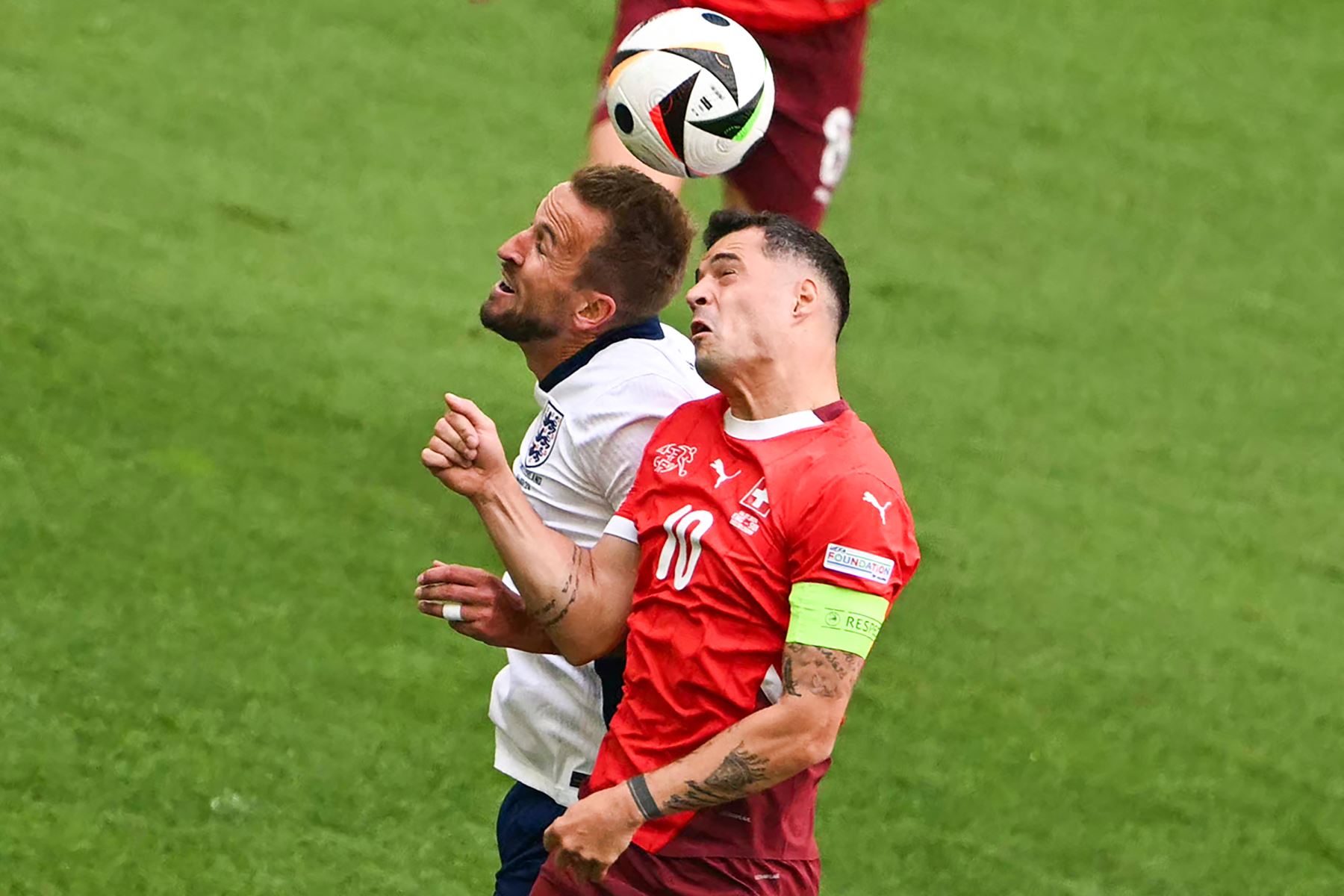 El delantero de Inglaterra Harry Kane y el mediocampista de Suiza  Granit Xhaka van a por un cabezazo durante el partido de fútbol de cuartos de final de la UEFA Euro 2024 entre Inglaterra y Suiza. AFP