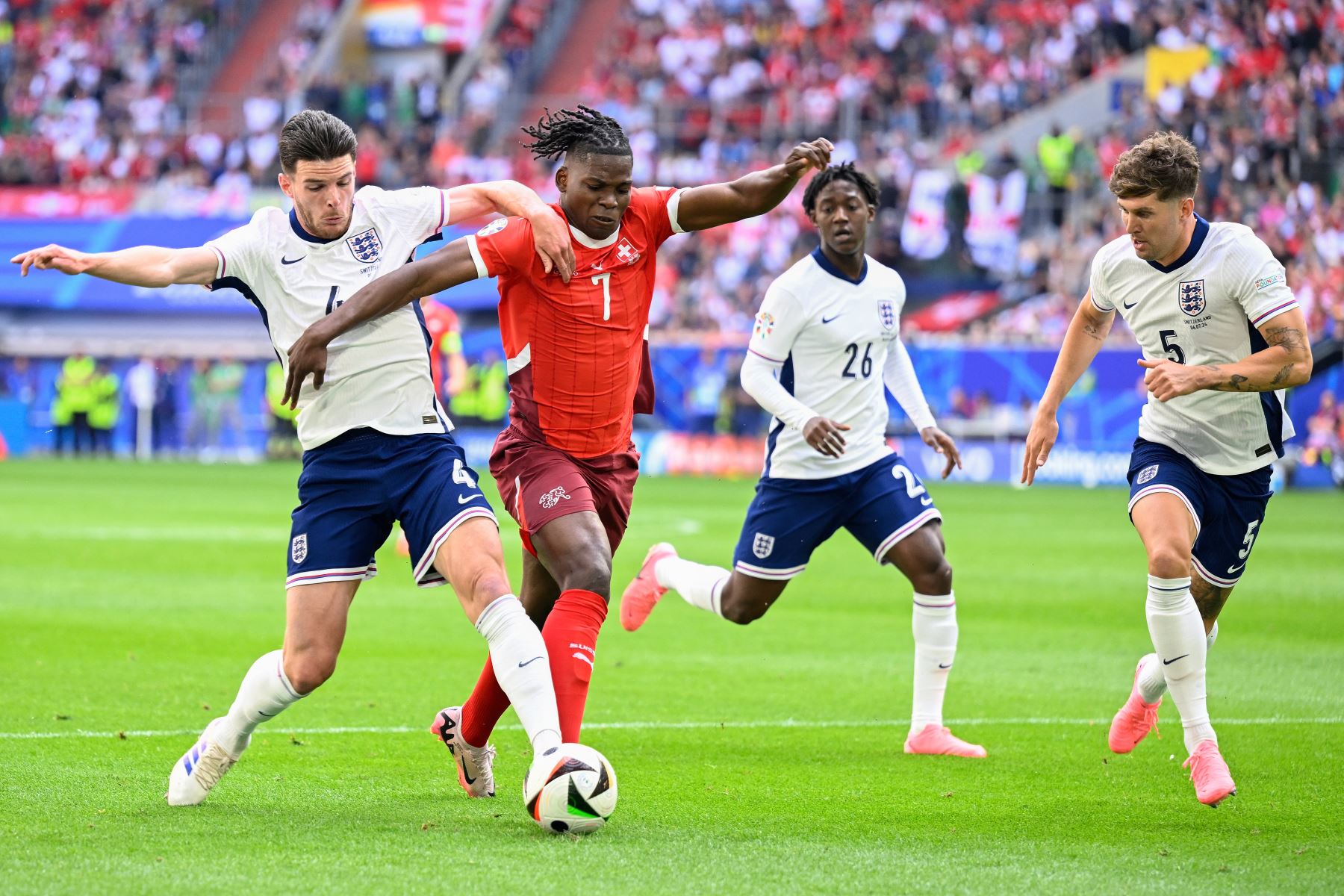 El mediocampista de Inglaterra  Declan Rice, el delantero de Suiza  Breel Embolo, el mediocampista de Inglaterra Kobbie Mainoo y el defensor de Inglaterra  John Stones luchan por el balón durante el partido de fútbol de cuartos de final de la UEFA Euro 2024 entre Inglaterra y Suiza. AFP