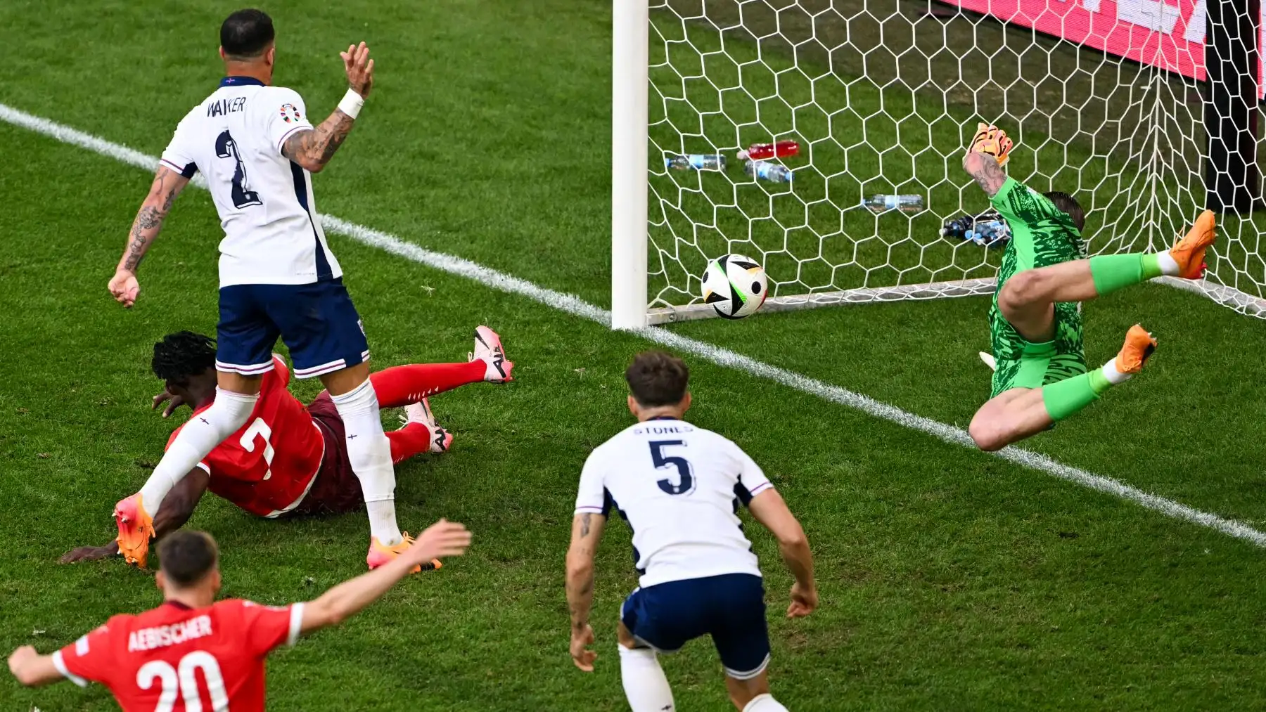 El delantero suizo  Breel Embolo  anota el primer gol de su equipo a pesar del defensor de Inglaterra  Kyle Walker y el portero de Inglaterra #01 Jordan Pickford. AFP