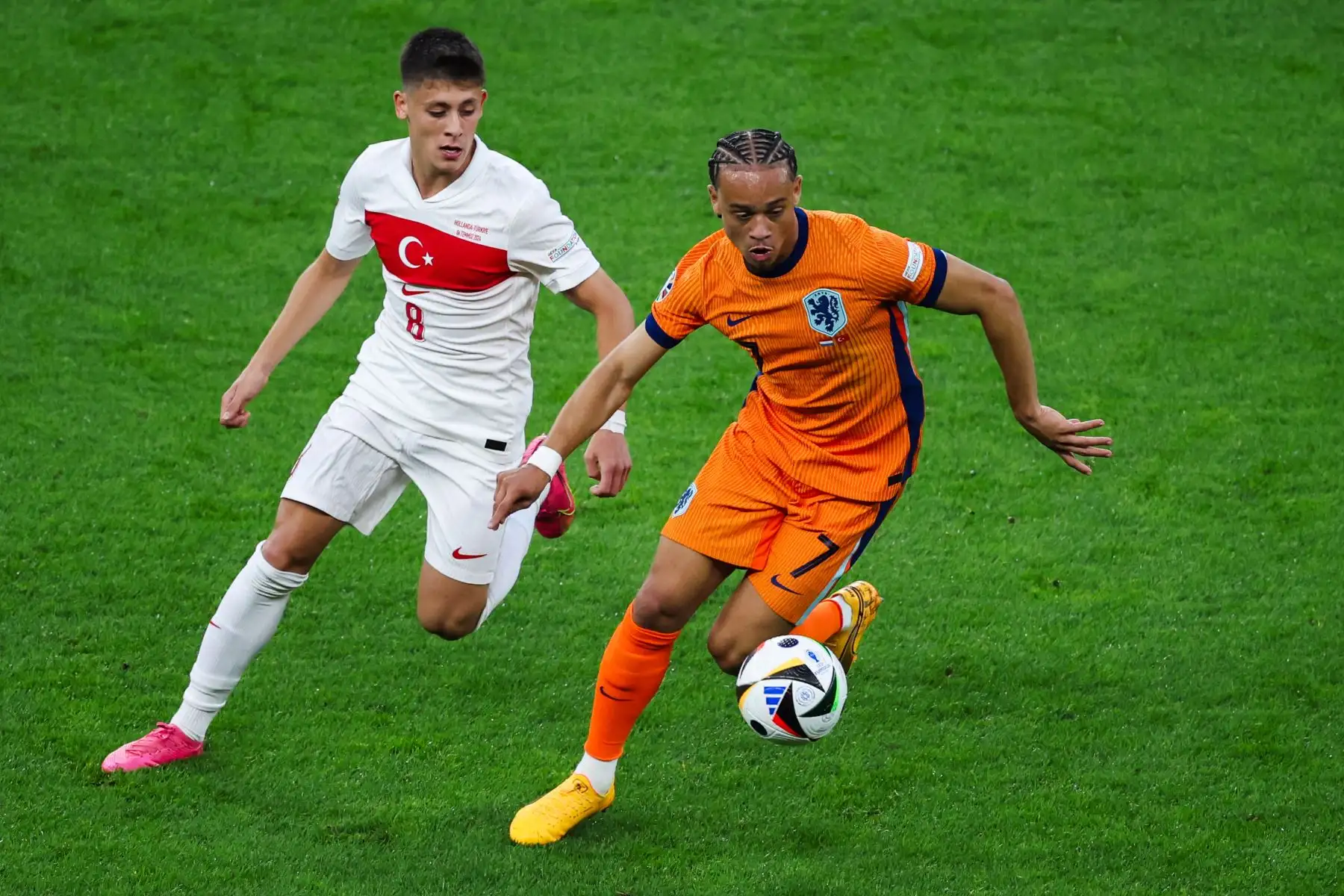 El delantero turco Arda Guler lucha por el balón con el delantero holandés Xavi Simons durante el partido de fútbol de cuartos de final de la UEFA Euro 2024 entre Holanda y Turquía. Foto: AFP