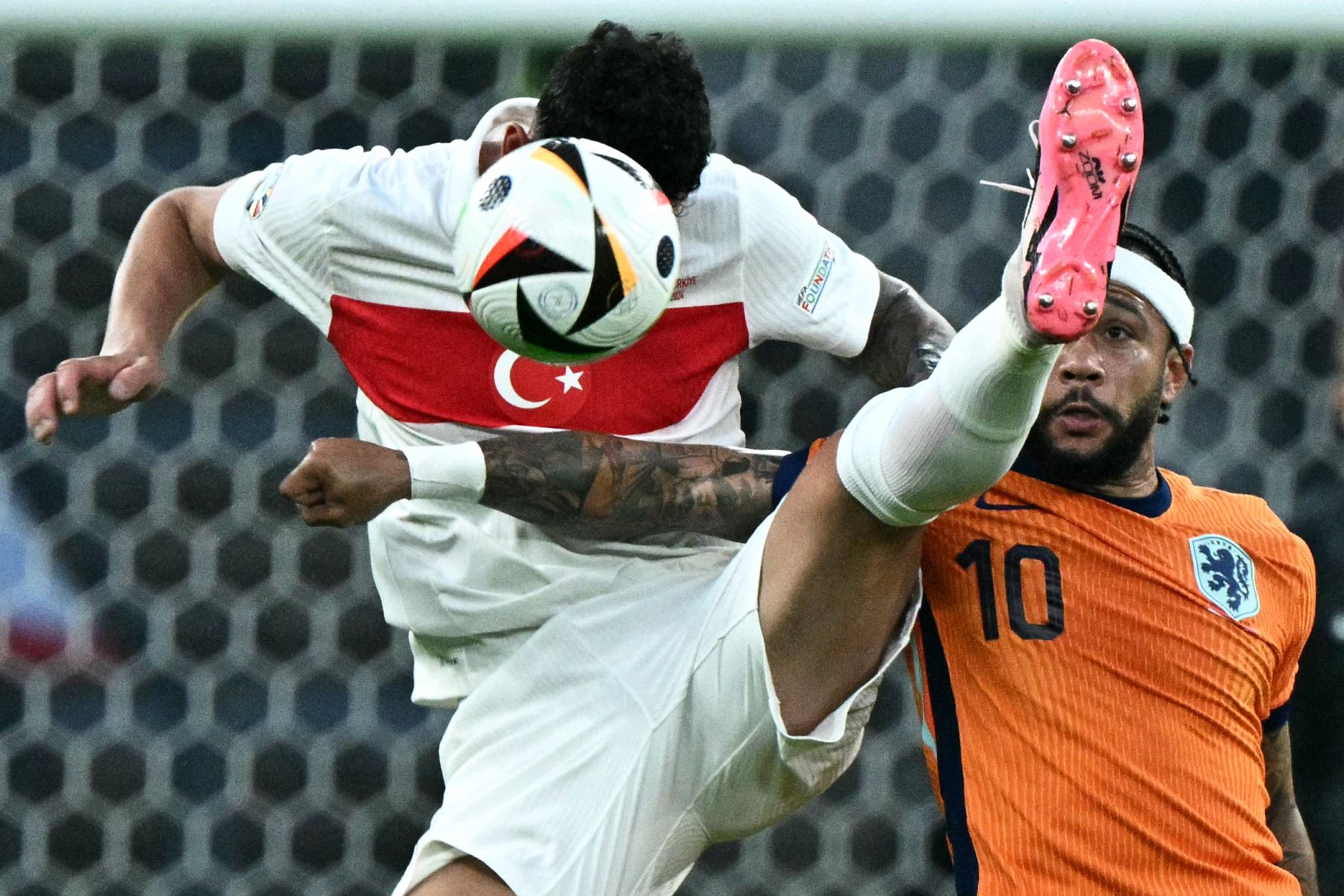 El defensor de Turquía  Samet Akaydin  lucha por el balón con el delantero holandés  Memphis Depay durante el partido de fútbol de cuartos de final de la UEFA Euro 2024 entre Holanda y Turquía. AFP