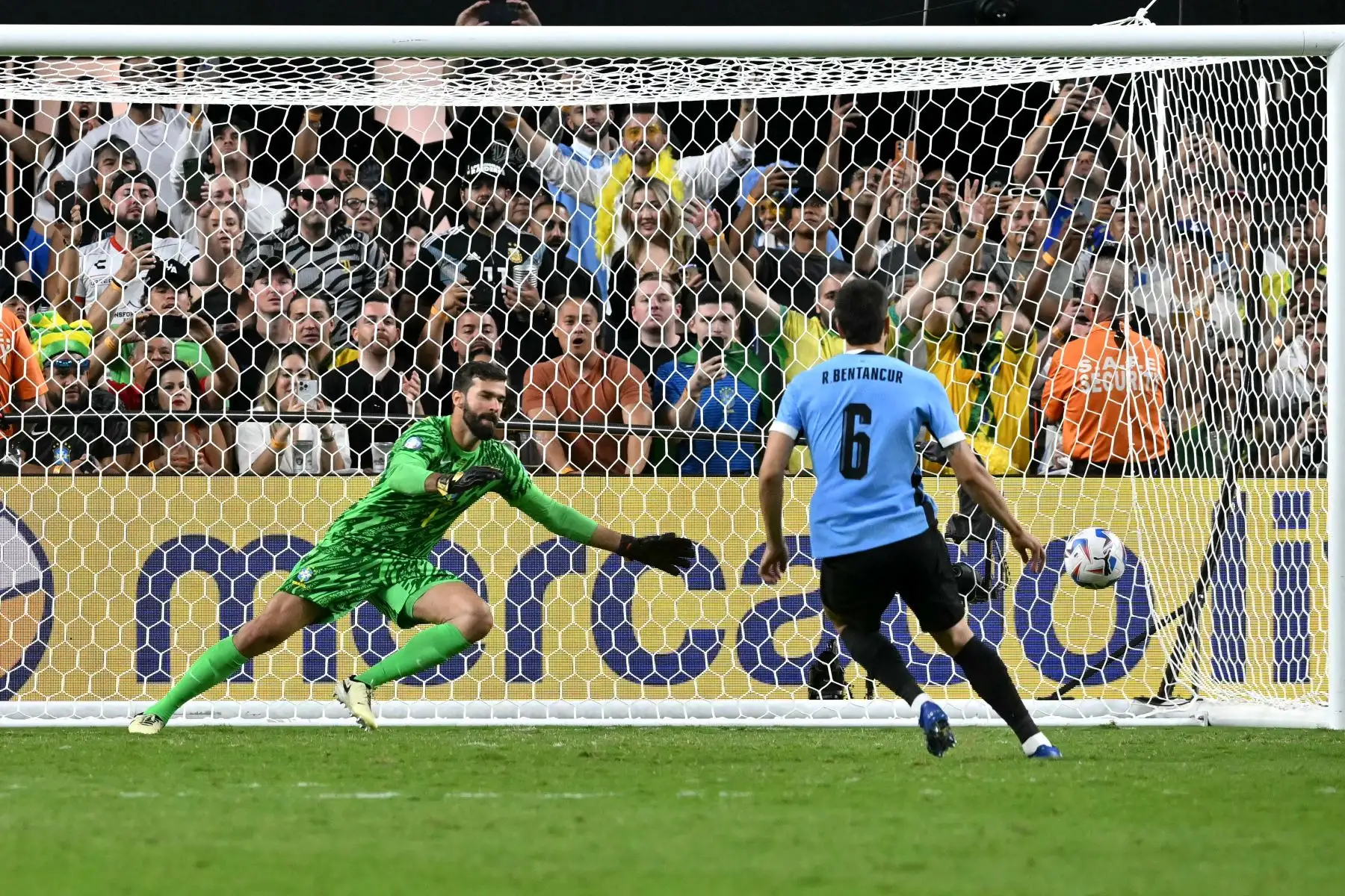 El mediocampista uruguayo Rodrigo Bentancur anota mientras el portero brasileño Alisson se lanza hacia el balón en una tanda de penales durante el partido de fútbol de cuartos de final del torneo Conmebol Copa América 2024 entre Uruguay y Brasil en el Allegiant Stadium de Las Vegas.
Foto: AFP
