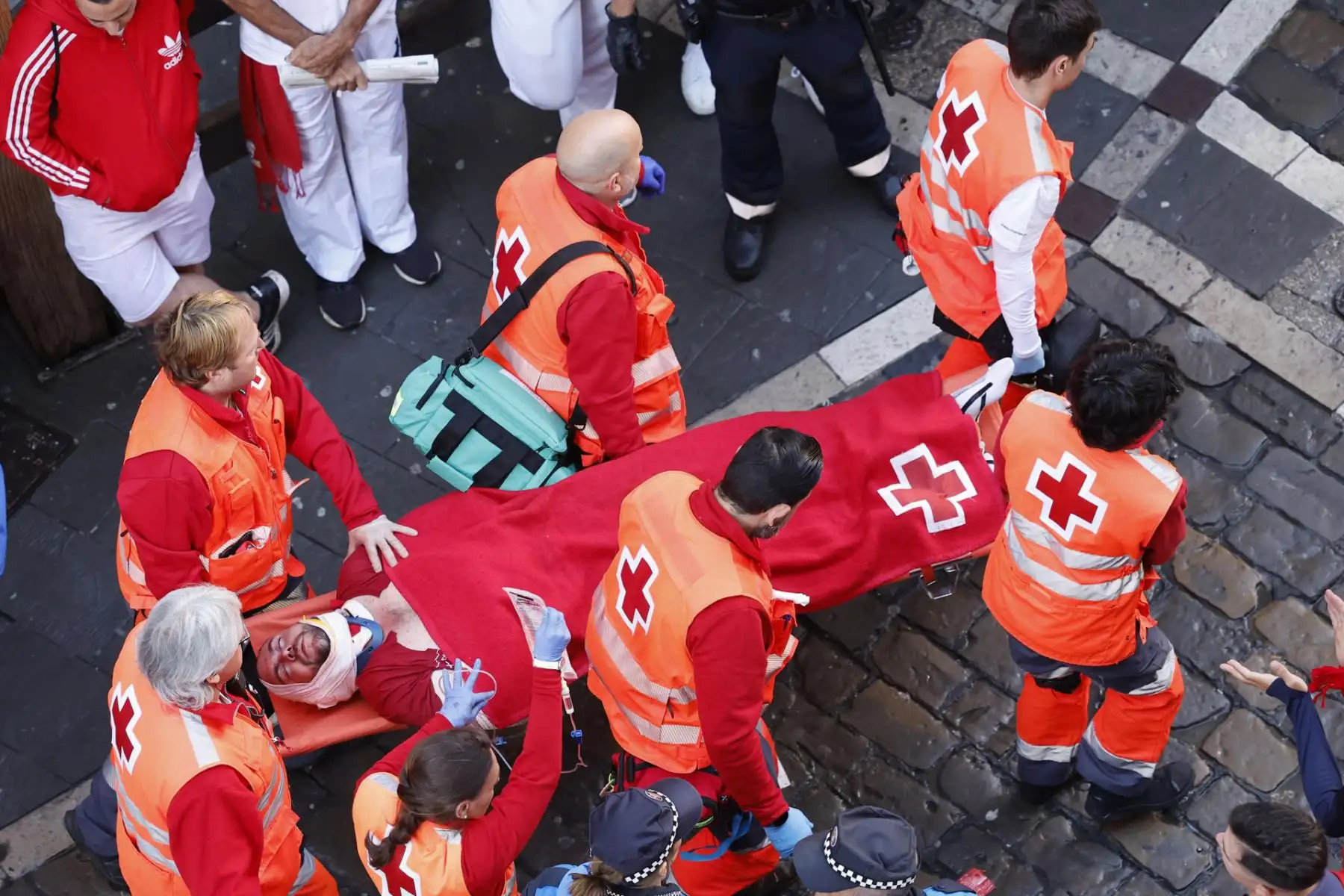 Miembros de los servicios sanitarios evacúan a un herido en la calle Estafeta durante el primer encierro de los Sanfermines en el Día de San Fermín, copatrón de Pamplona, ciudad que celebra los Sanfermines, Fiesta de Interés Turístico Internacional, hasta el próximo 14 de julio. EFE