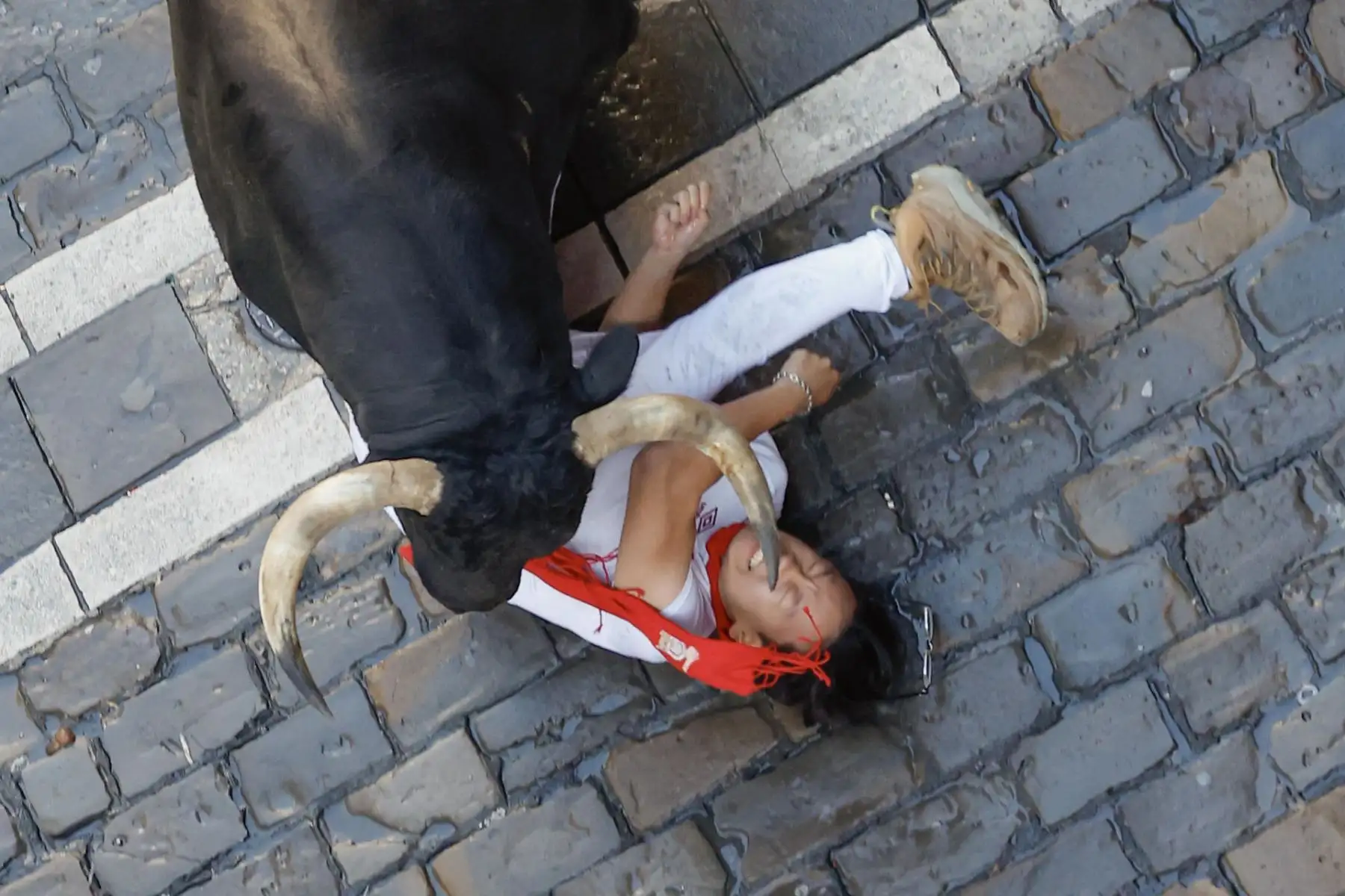 Un corredor es arrollado por uno de los toros durante el primer encierro de los Sanfermines. EFE
