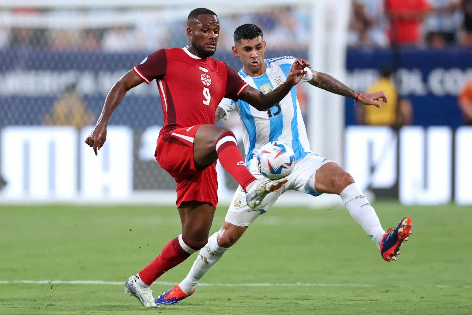 El delantero canadiense Cyle Larin lucha por el balón con el defensor argentino Cristian Romero durante el partido de fútbol semifinal del torneo Conmebol Copa América 2024 entre Argentina y Canadá. Foto: ANDINA/ AFP