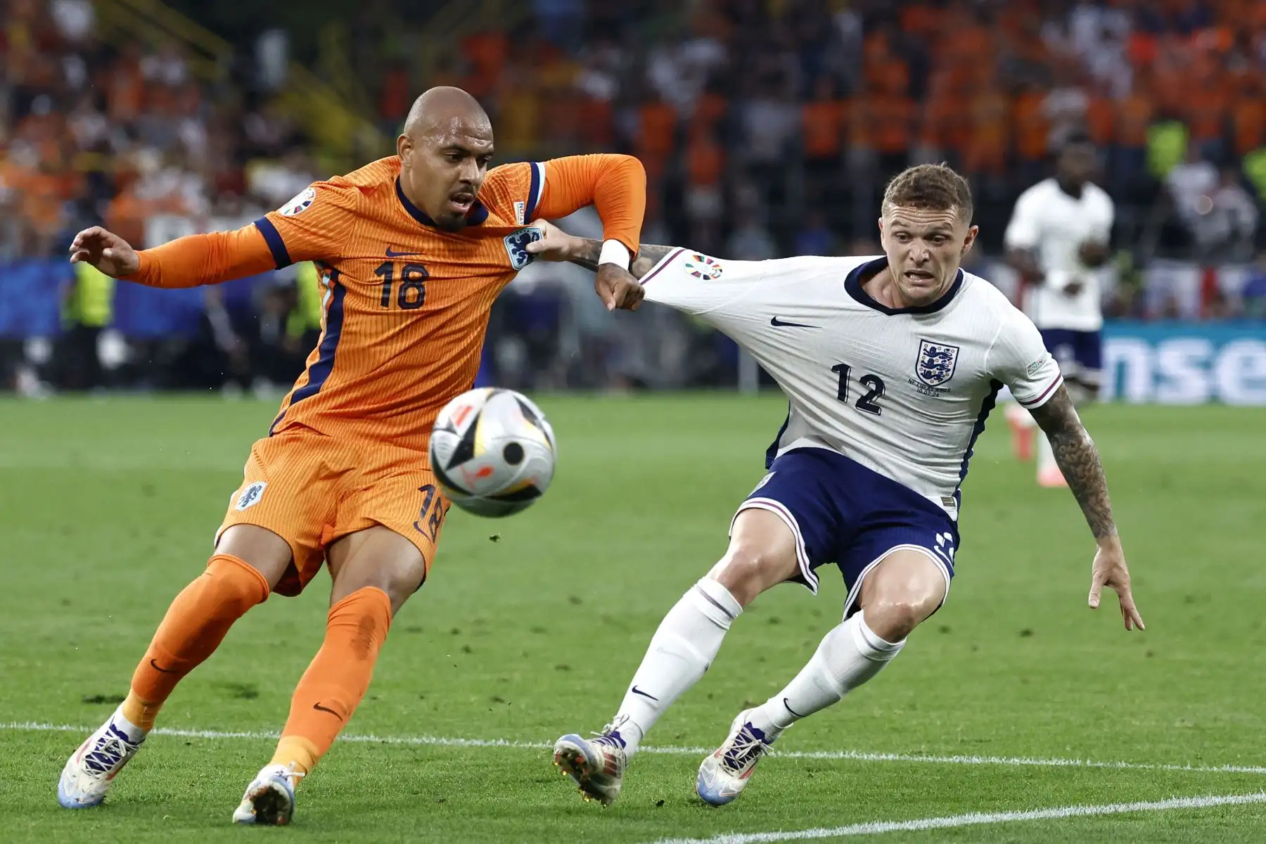 El delantero holandés Donyell Malen  lucha por el balón con el defensor inglés Kieran Trippier durante el partido de fútbol semifinal de la UEFA Euro 2024 entre Holanda e Inglaterra. Foto: ANDINA/AFP