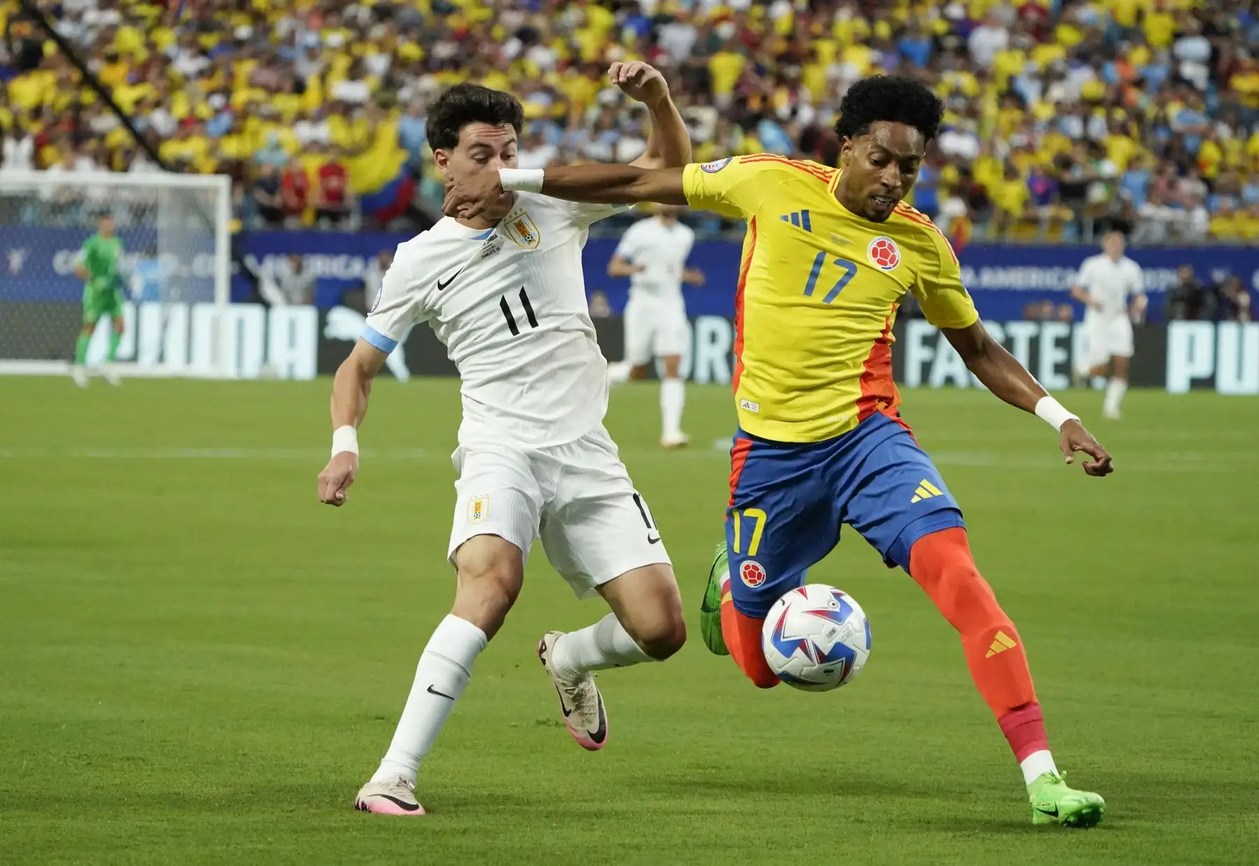 El delantero uruguayo  Facundo Pellistri y el defensor colombiano Johan Mojica compiten por el balón durante el partido de fútbol semifinal del torneo Conmebol Copa América 2024 entre Uruguay y Colombia. 
Foto: ANDINA/AFP
