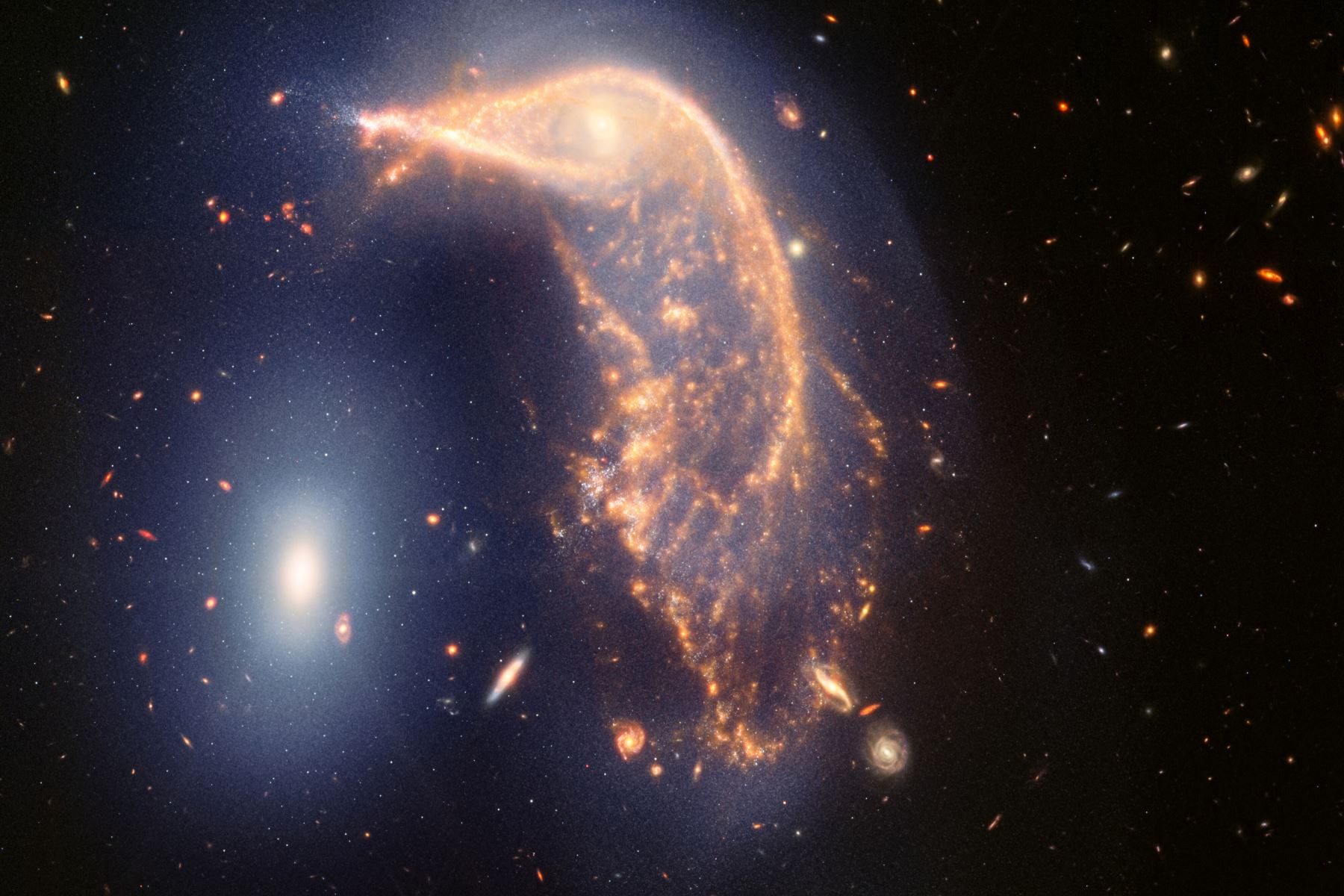 Celebrando dos años de ciencia, esta nueva imagen de Webb muestra dos galaxias: un pingüino (NGC 2936) custodiando un huevo (NGC 2937). Webb revela que están en un abrazo cósmico, unidos por una neblina azul de estrellas y gas. Foto: @NASAWebb