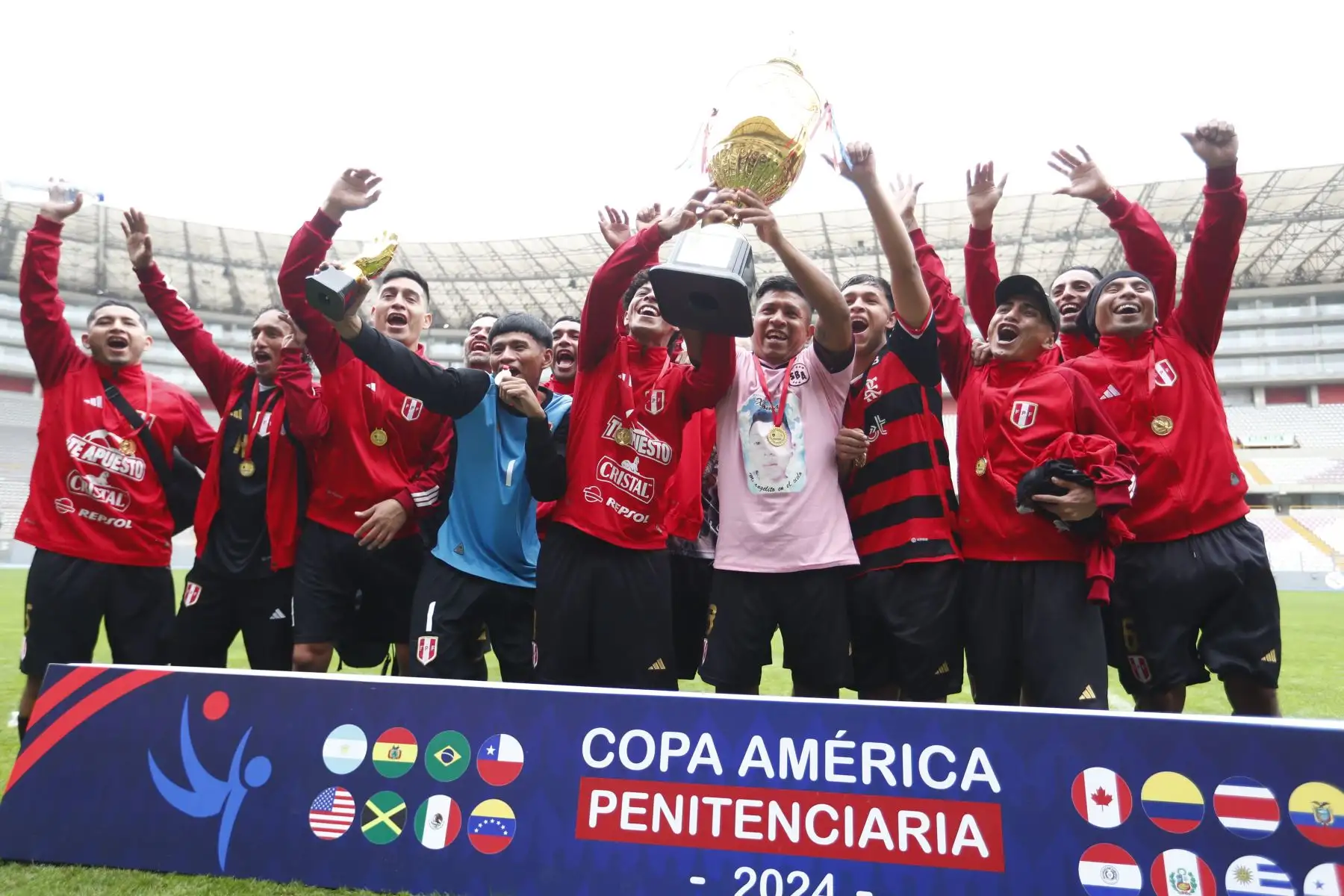Internos del Establecimiento Penitenciario del Callao, representando a Perú, celebran su triunfo en la Copa América Penitenciaria 2024 en el Estadio Nacional, tras derrotar en la final por 3-0 a los internos del Establecimiento penitenciario de Chincha, quienes representaban a Costa Rica. Foto: ANDINA/Daniel Bracamonte