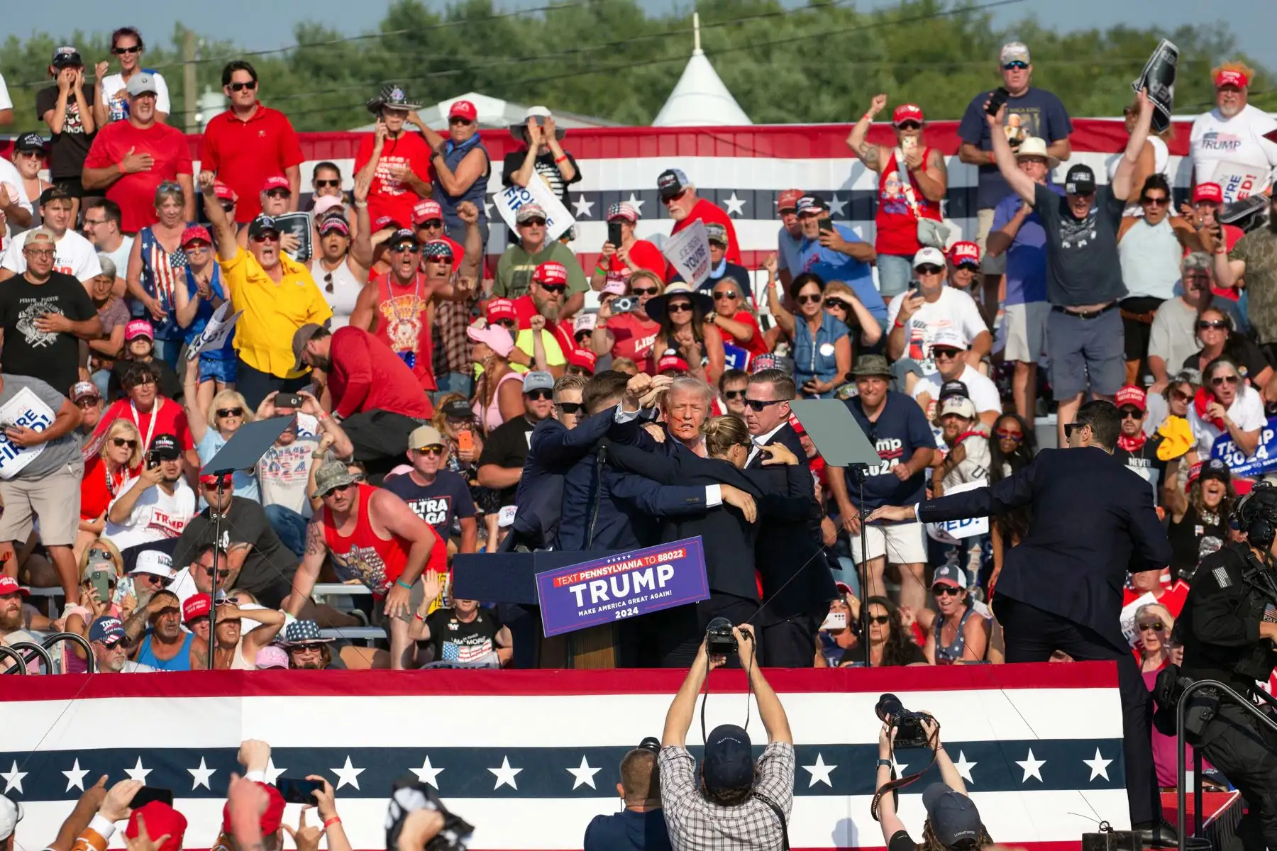 2024. Donald Trump con lo que parece ser sangre en el rostro rodeado de agentes del servicio secreto cuando lo sacan del escenario en un evento de campaña en Butler Farm Show Inc. en Butler, Pensilvania.
Foto: AFP