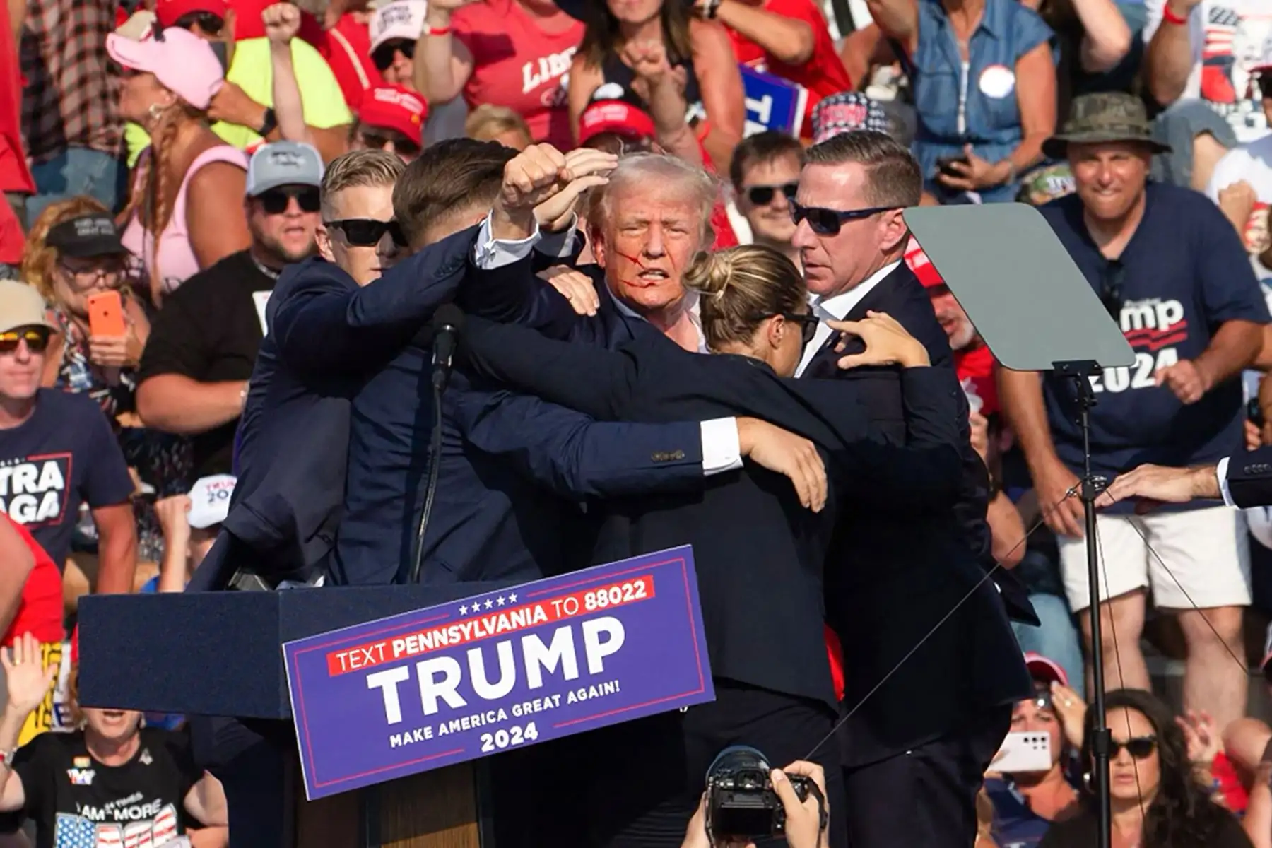 2024. Donald Trump con lo que parece ser sangre en el rostro rodeado de agentes del servicio secreto cuando lo sacan del escenario en un evento de campaña en Butler Farm Show Inc. en Butler, Pensilvania.
Foto: AFP