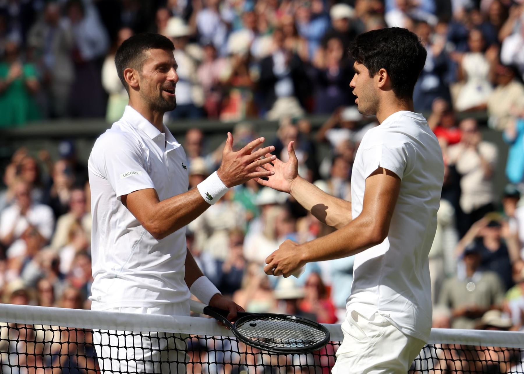 Carlos Alcaraz de España le da la mano a Novak Djokovic de Serbia después de ganar la final masculina en el Campeonato de Wimbledon. EFE