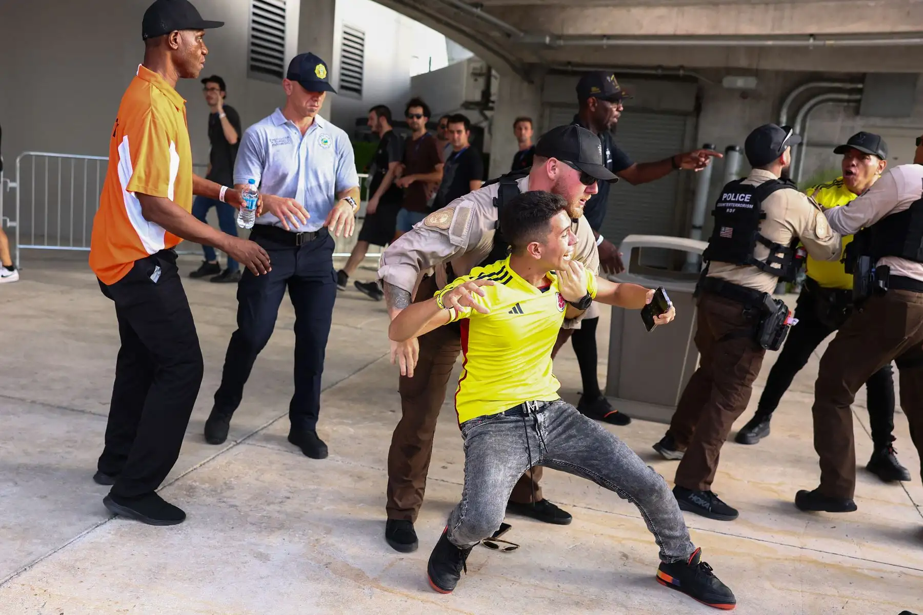 Agentes de policía intentan arrestar a un fanático colombiano afuera del estadio del partido final de la CONMEBOL Copa América 2024 entre Argentina y Colombia en el Hard Rock Stadium.
Foto: AFP