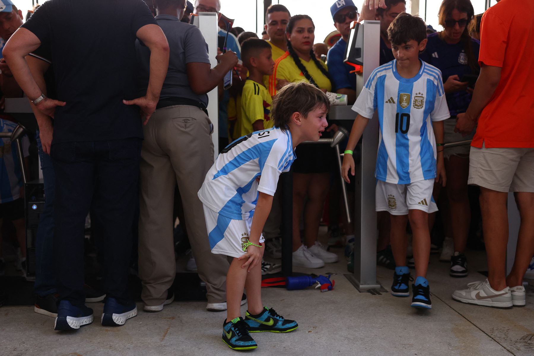 Un joven aficionado de Argentina llora al entrar al estadio en medio de disturbios fuera del estadio durante el partido final de la CONMEBOL Copa América 2024 entre Argentina y Colombia en el Hard Rock Stadium .
Foto: AFP