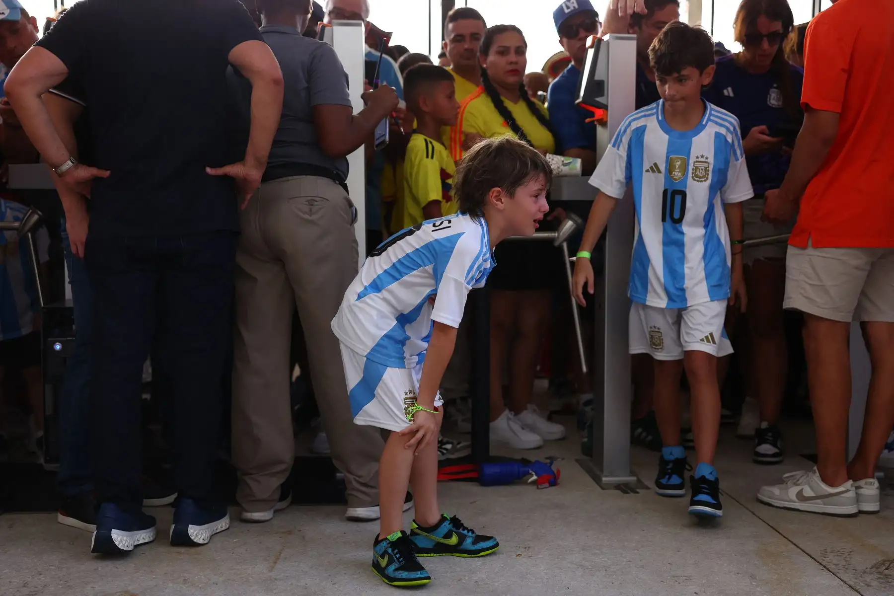 Un joven aficionado de Argentina llora al entrar al estadio en medio de disturbios fuera del estadio durante el partido final de la CONMEBOL Copa América 2024 entre Argentina y Colombia en el Hard Rock Stadium .
Foto: AFP