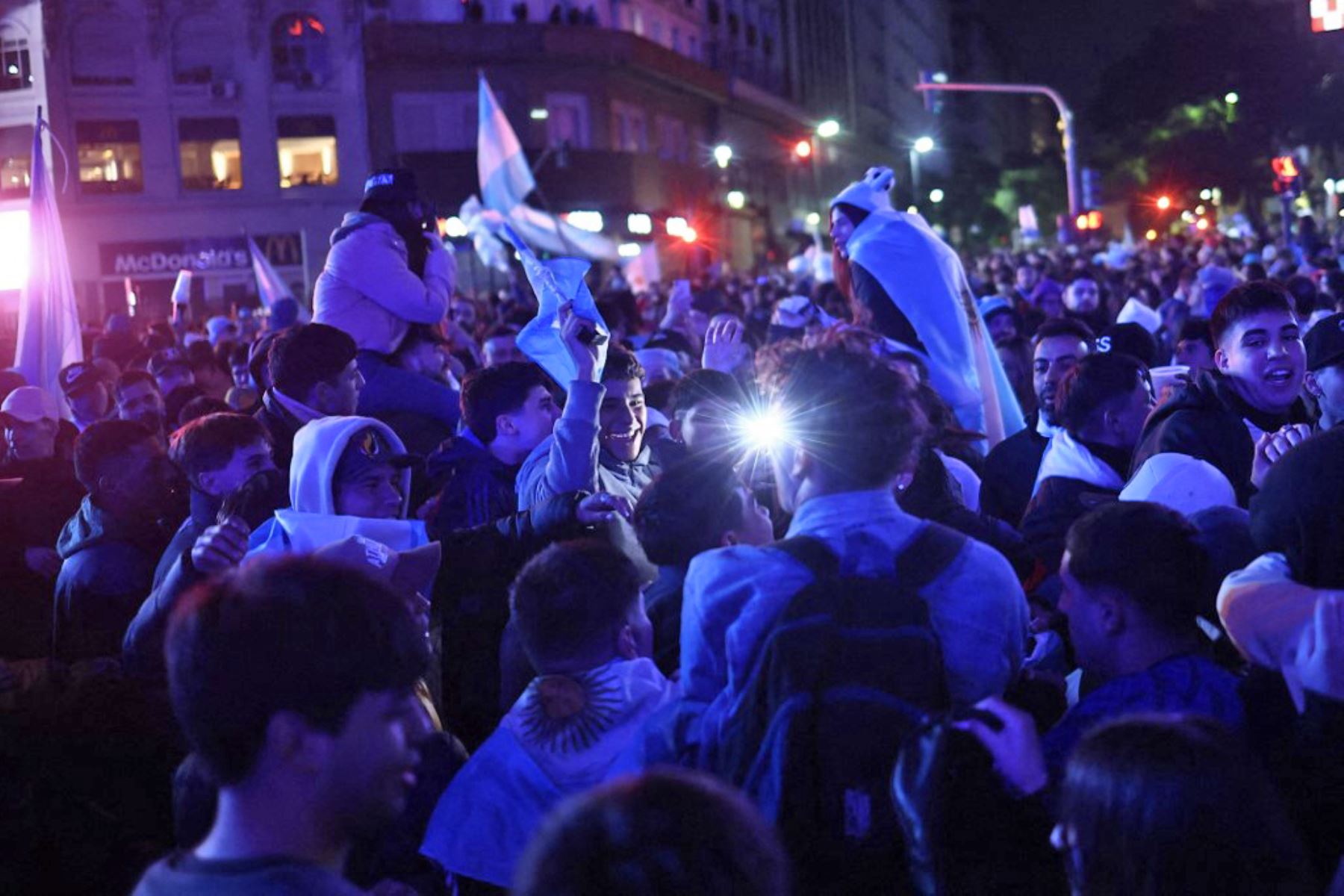 Al grito de "Dale campeón!" los fanáticos, muchos envueltos en banderas argentinas, desataron la fiesta pese a las bajas temperaturas del invierno austral, en los alrededores del emblema porteño, epicentro de los festejos en Buenos Aires. Foto: AFP