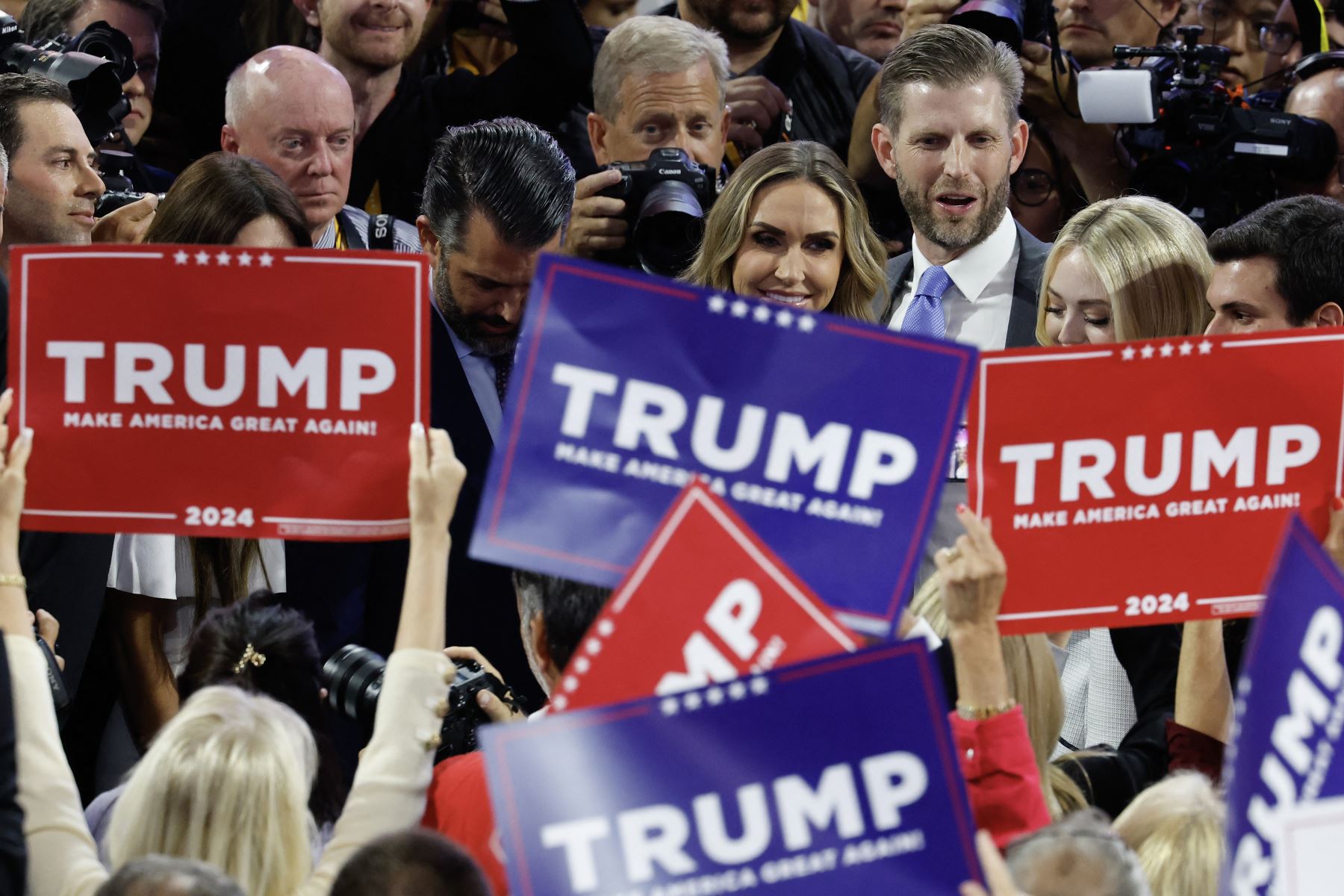 La gente sostiene carteles mientras familiares del candidato presidencial republicano, el expresidente estadounidense Donald Trump, aparecen en el primer día de la Convención Nacional Republicana en el Foro Fiserv.
Foto: AFP