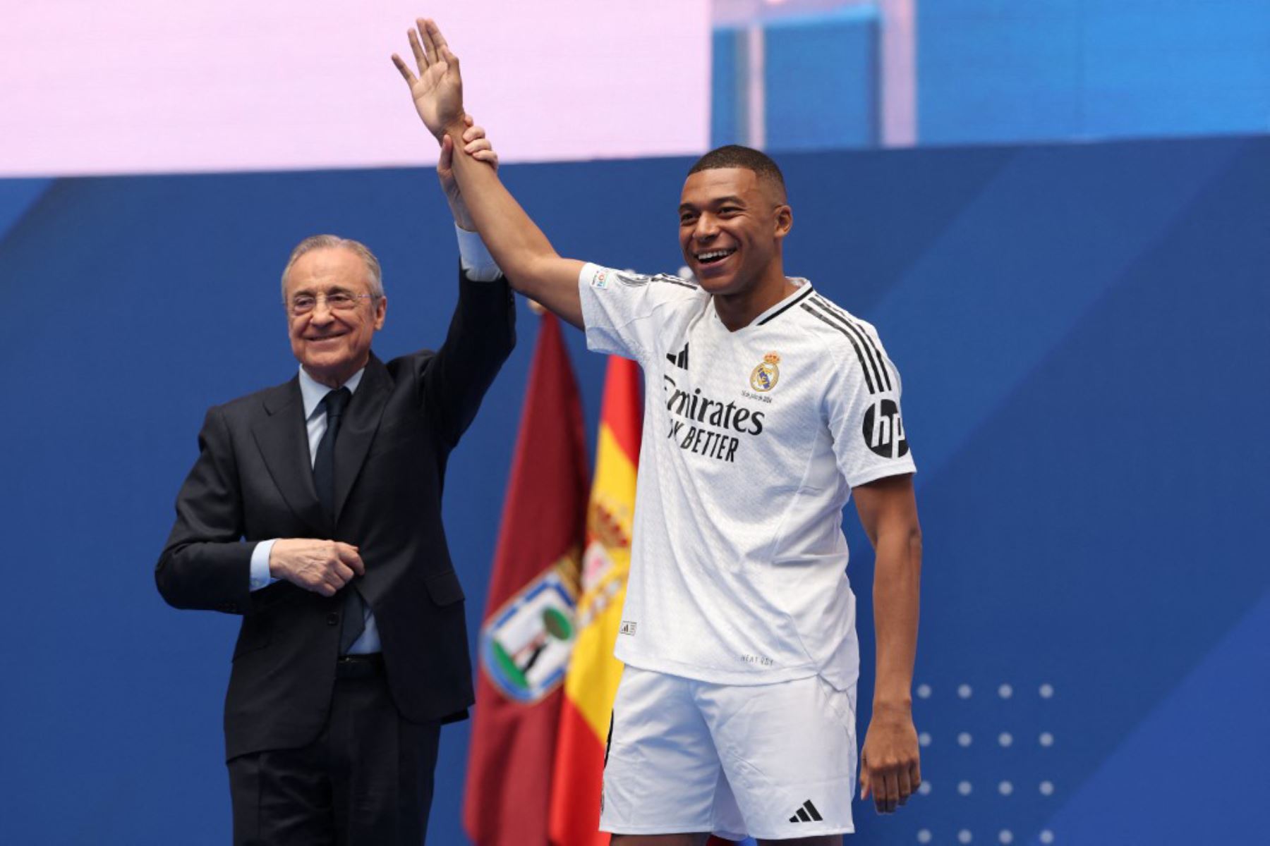 El delantero francés Kylian Mbappé saluda a los aficionados junto al presidente del Real Madrid, Florentino Pérez, durante una primera aparición como jugador del Real Madrid en el estadio Santiago Bernabeu de Madrid, tras firmar su nuevo contrato de cinco temporadas. Foto: AFP