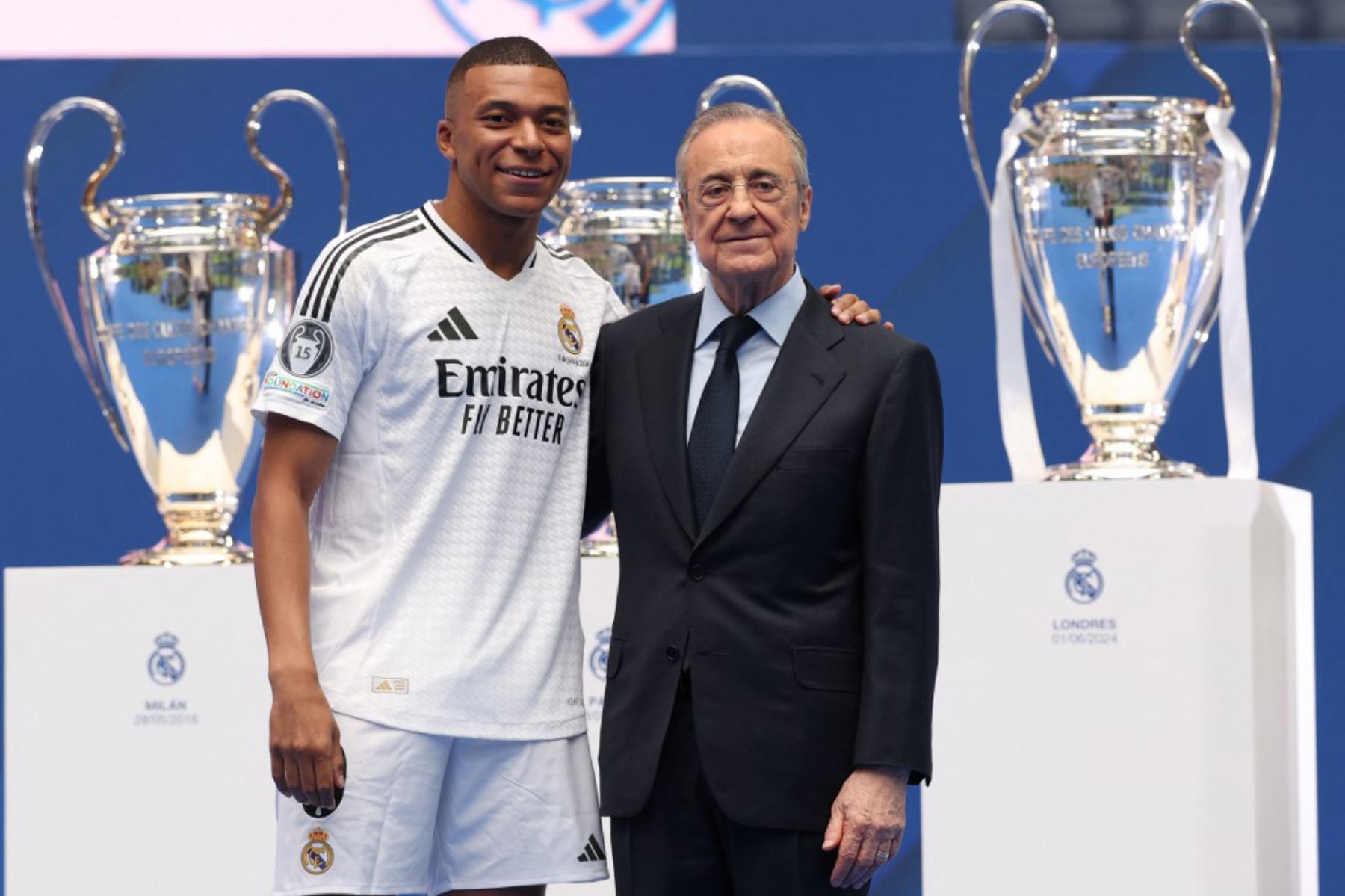 El delantero francés Kylian Mbappé saluda a los aficionados junto al presidente del Real Madrid, Florentino Pérez, durante una primera aparición como jugador del Real Madrid en el estadio Santiago Bernabeu de Madrid, tras firmar su nuevo contrato de cinco temporadas. Foto: AFP