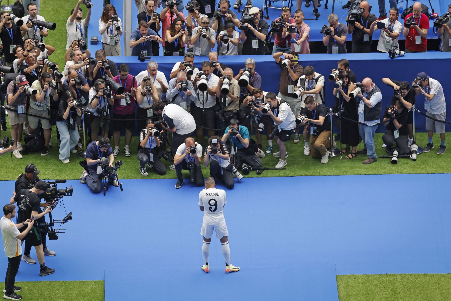 El delantero francés Kylian Mbappé posa para los medios de comunicación durante su primera aparición como jugador del Real Madrid en el estadio Santiago Bernabéu de Madrid. Foto: AFP