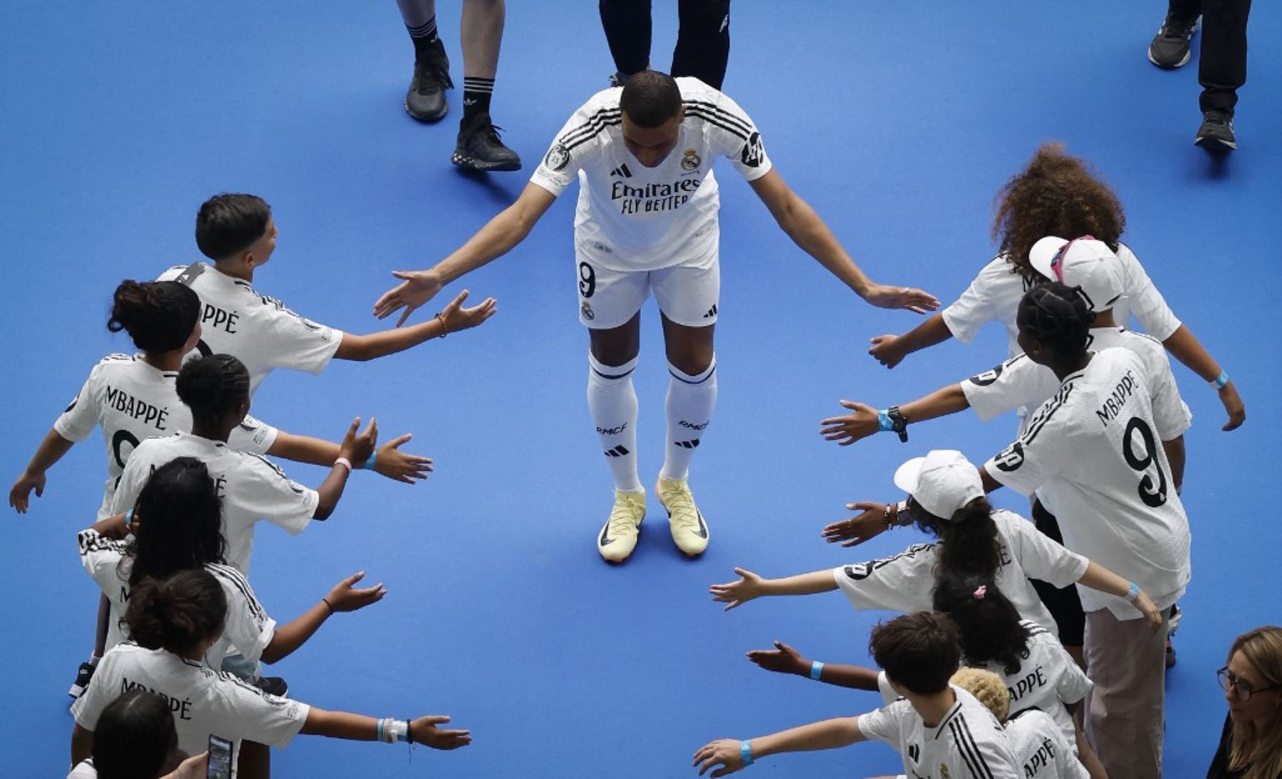 El delantero francés Kylian Mbappé, saluda a los niños durante su primera aparición como jugador del Real Madrid en el estadio Santiago Bernabéu de Madrid. Foto: AFP