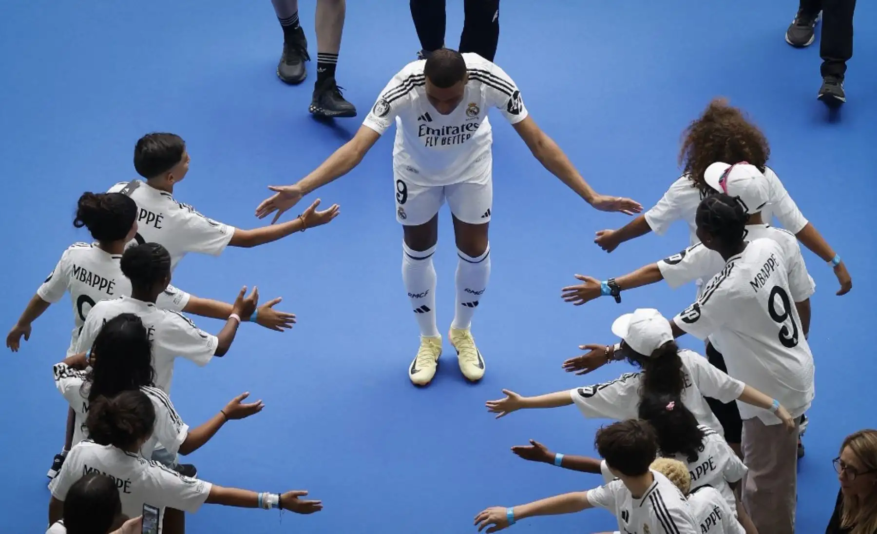 El delantero francés Kylian Mbappé, saluda a los niños durante su primera aparición como jugador del Real Madrid en el estadio Santiago Bernabéu de Madrid. Foto: AFP