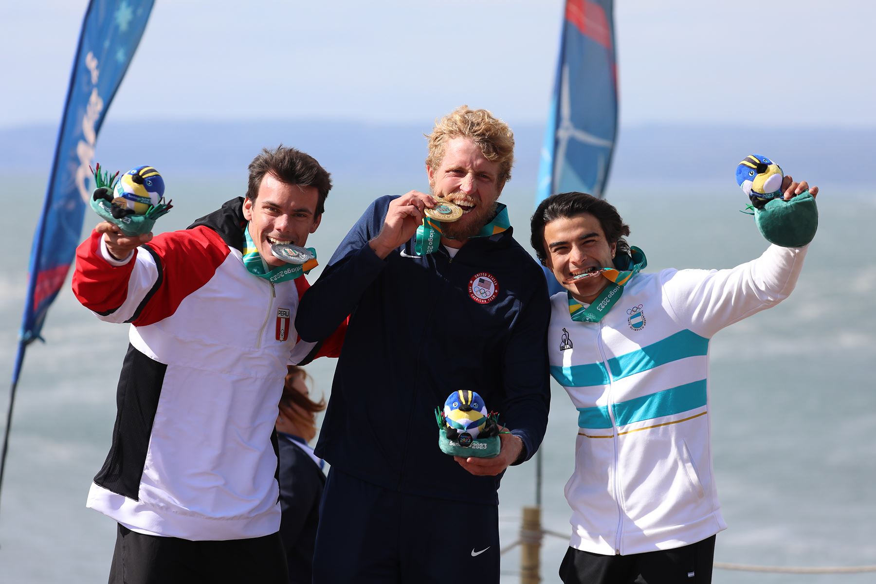 Santiago de Chile,  30 octubre 2023 .- Connor Baxter (c) de los Estados Unidos, medalla de oro, Itzel Delgado (i) de Perú, plata, y Santino Basaldella de Argentina, bronce, posan en el podio de surf SUP race durante los Juegos Panamericanos 2023. Foto: EFE