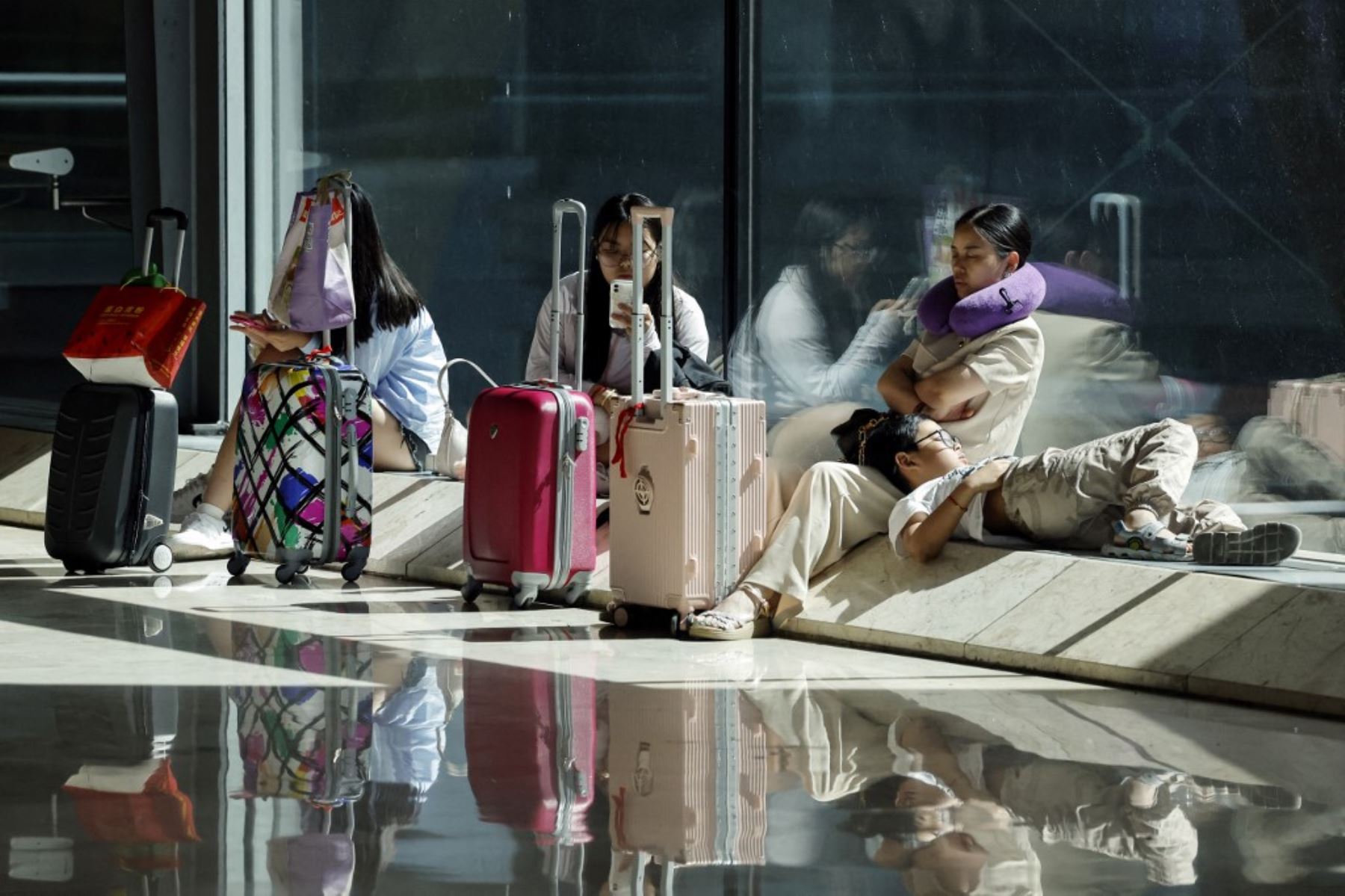 Los pasajeros descansan mientras esperan el check-in en la Terminal 4 del aeropuerto Adolfo Suárez Barajas de Madrid, España, el 19 de julio de 2024, en medio de una interrupción masiva de TI a nivel mundial. Foto: AFP