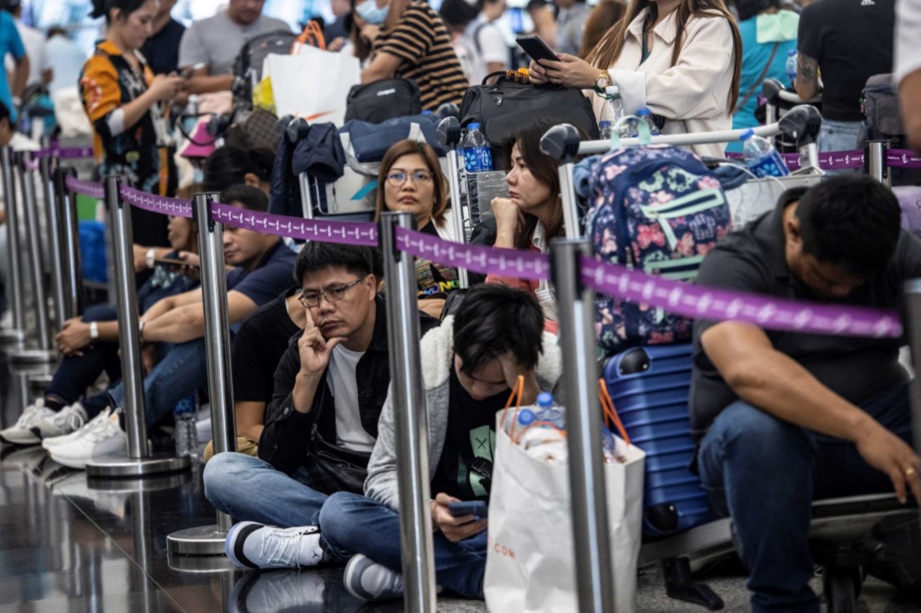 Los pasajeros esperan a realizar su check-in en el Aeropuerto Internacional de Hong Kong el 19 de julio de 2024, mientras algunas aerolíneas recurren al check-in manual debido a una interrupción mundial de Microsoft. Foto: AFP