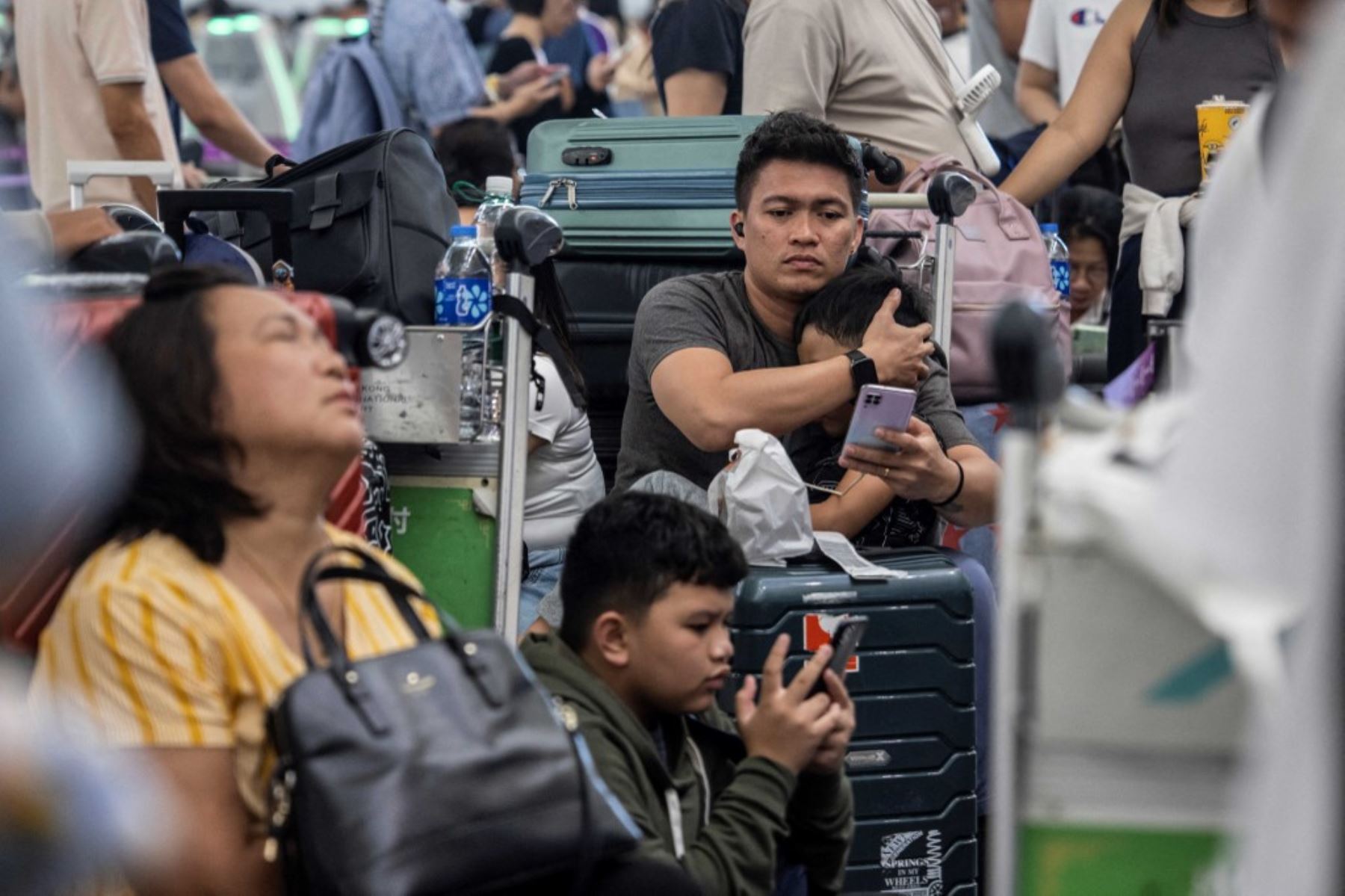 Los pasajeros esperan a realizar su check-in en el Aeropuerto Internacional de Hong Kong el 19 de julio de 2024, mientras algunas aerolíneas recurren al check-in manual debido a una interrupción mundial de Microsoft. Foto: AFP