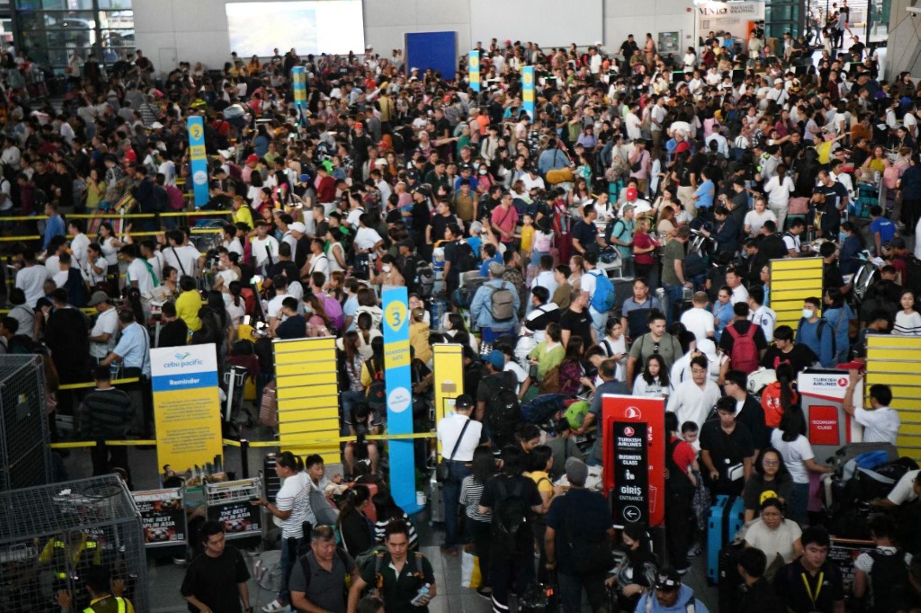 Los pasajeros se agolpan en los mostradores de salida de la aerolínea Cebu Pacific en la Terminal 3 del aeropuerto internacional Ninoy Aquino en Manila. Una interrupción importante causó estragos en los sistemas informáticos en todo el mundo, provocando la suspensión de vuelos en los Estados Unidos, descarrilando transmisiones de televisión en el Reino Unido e impactando telecomunicaciones en Australia. Foto: AFP