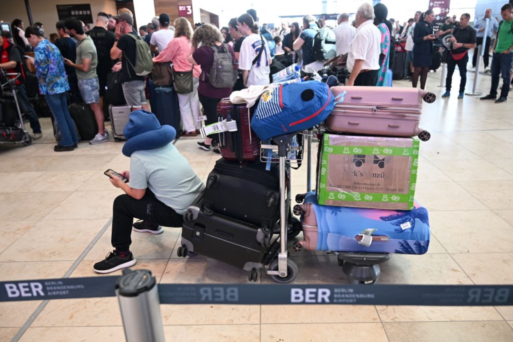 Pasajeros realizan colas para las salidas en el aeropuerto Berlín-Brandenburgo en Schoenefeld, al sureste de la capital alemana, después de que los vuelos se suspendieran temporalmente en el aeropuerto debido a una interrupción global de TI que afectó a Alemania. Foto: AFP