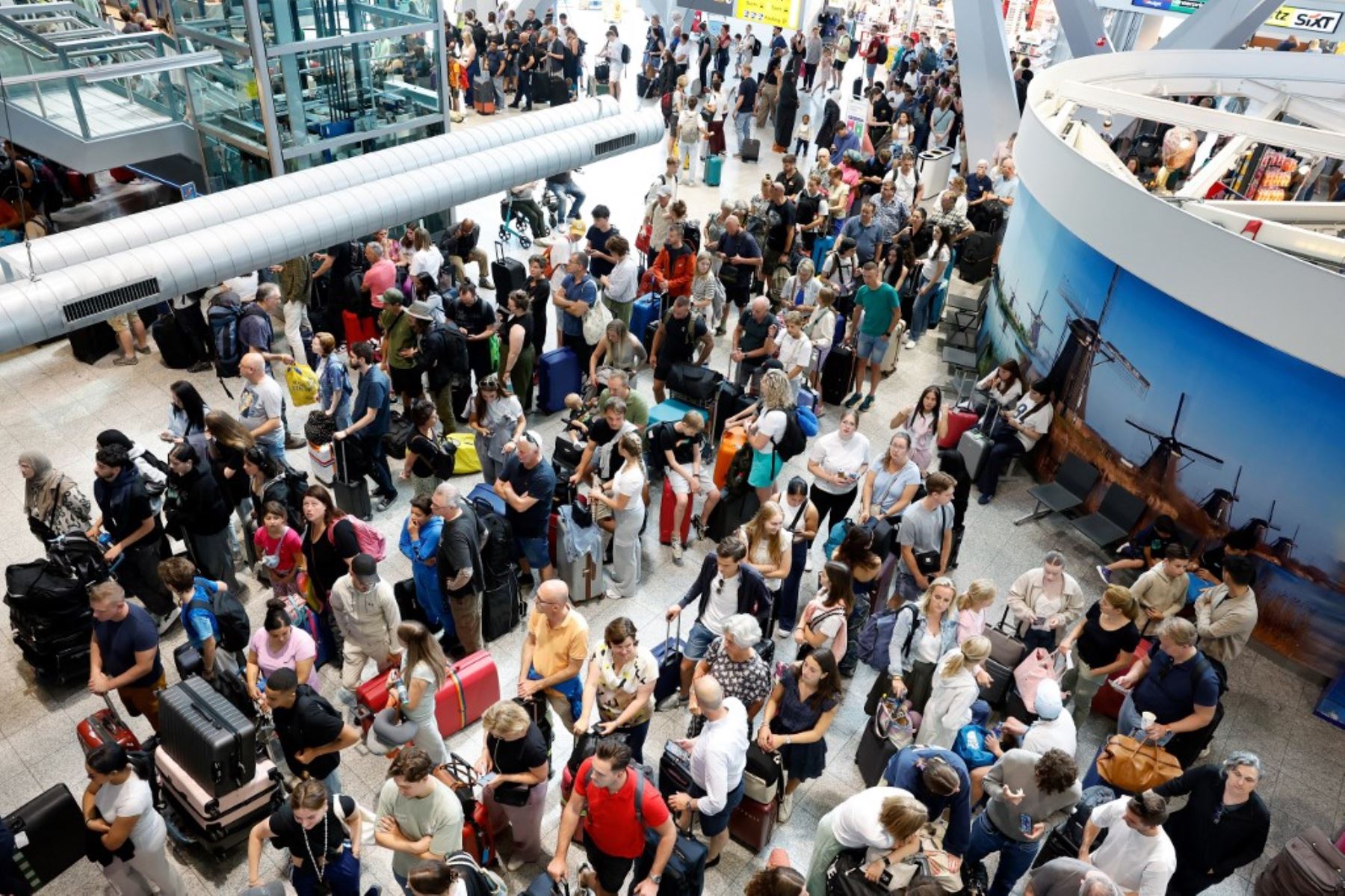 Viajeros se reúnen dentro del aeropuerto de Eindhoven debido a un error que provocó una interrupción global de TI que afectó a los aeropuertos, haciendo imposible que la mayoría de los pasajeros realizaran el check-in. Uno de los mayores fallos informáticos de los últimos años, aparentemente provocado por una actualización de un programa antivirus que inutilizó los sistemas de facturación en aeropuertos de todo el mundo, obligándolos a ser manejados manualmente, con posibles retrasos. Foto: AFP