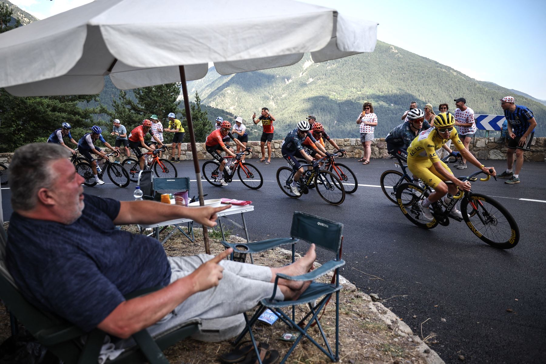 Un espectador aplaude al borde de la carretera mientras el ciclista esloveno del equipo UAE Team Emirates, Tadej Pogacar, vistiendo el maillot amarillo de líder general, pedalea en el ascenso del Col de la Colmiane durante la 20ª etapa de la 111ª edición de la carrera ciclista del Tour de Francia, 132,8 km entre Niza y Col de la Couillole, sureste de Francia.
Foto: AFP