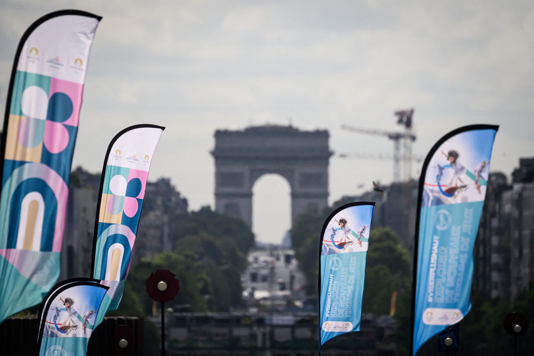 Esta fotografía muestra el Arco de Triunfo detrás de pancartas con el logotipo de los Juegos Olímpicos de París 2024 en el distrito comercial de La Défense, al oeste de París, unos días antes de la ceremonia de apertura. 
Foto: AFP