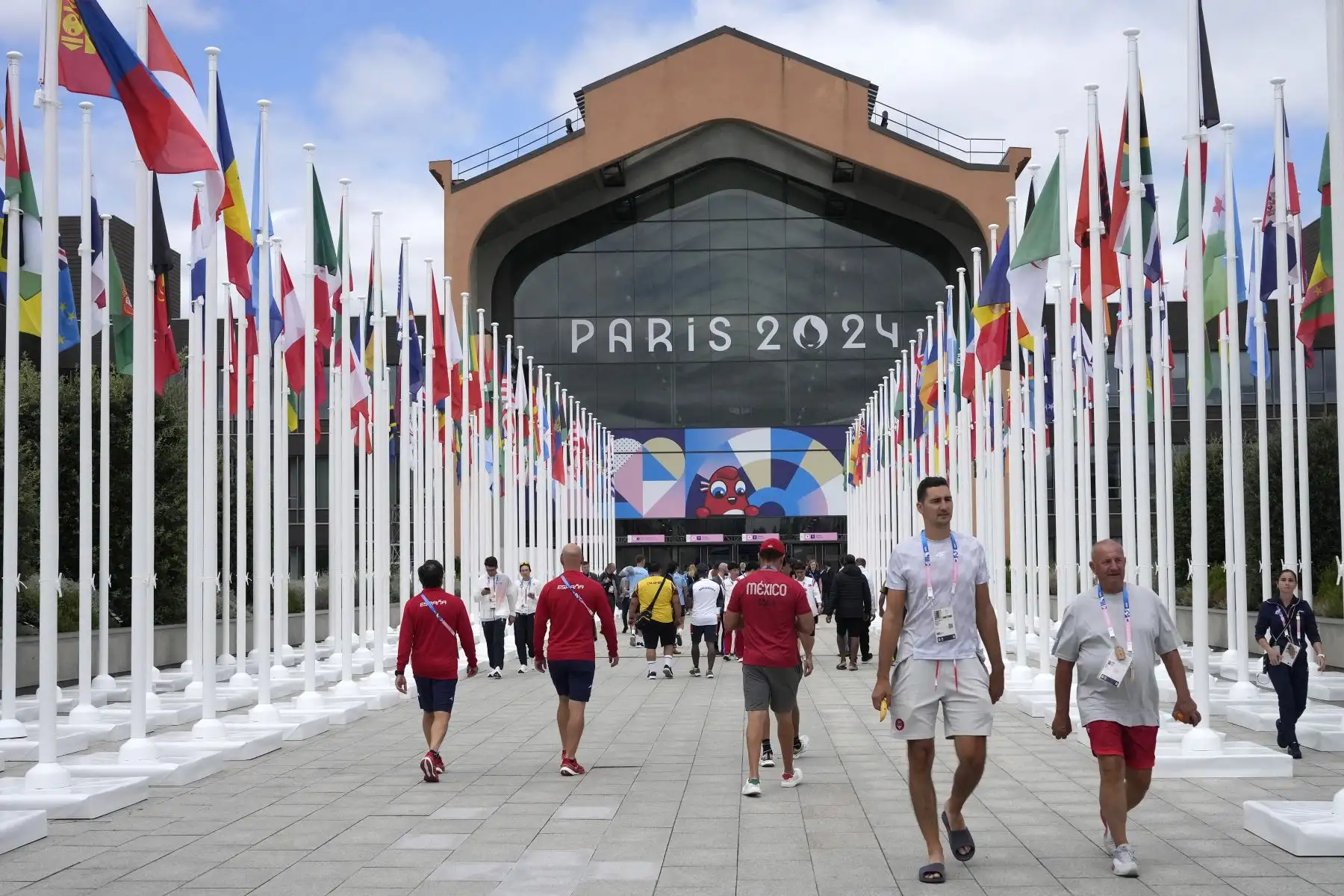 Los participantes de los Juegos Olímpicos y Paralímpicos de París 2024 caminan frente a la cafetería de la Villa Olímpica, en Saint-Denis, al norte de París, antes de la ceremonia de apertura de los Juegos Olímpicos y Paralímpicos de París 2024.
Foto: AFP