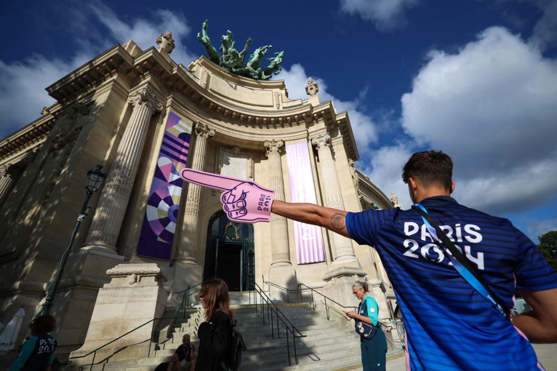 Un voluntario de los Juegos Olímpicos y Paralímpicos de París 2024 hace gestos para indicar la dirección mientras otros voluntarios llegan para participar en una sesión de entrenamiento en el Grand Palais de París .
Foto: AFP