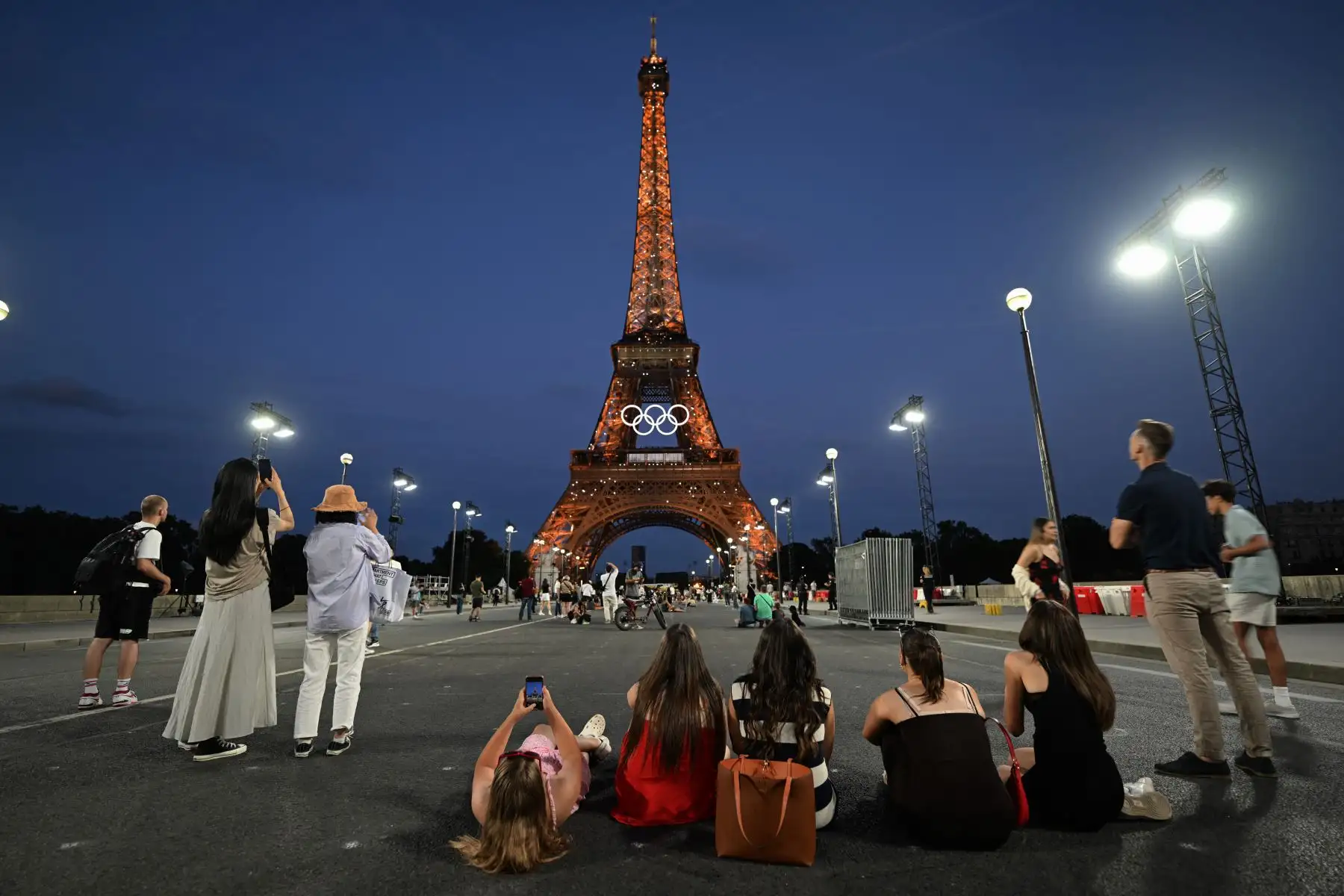 Turistas toman fotografías frente a la Torre Eiffel en París, Francia, antes de los Juegos Olímpicos y Paralímpicos de París 2024. Foto: ANDINA/AFP