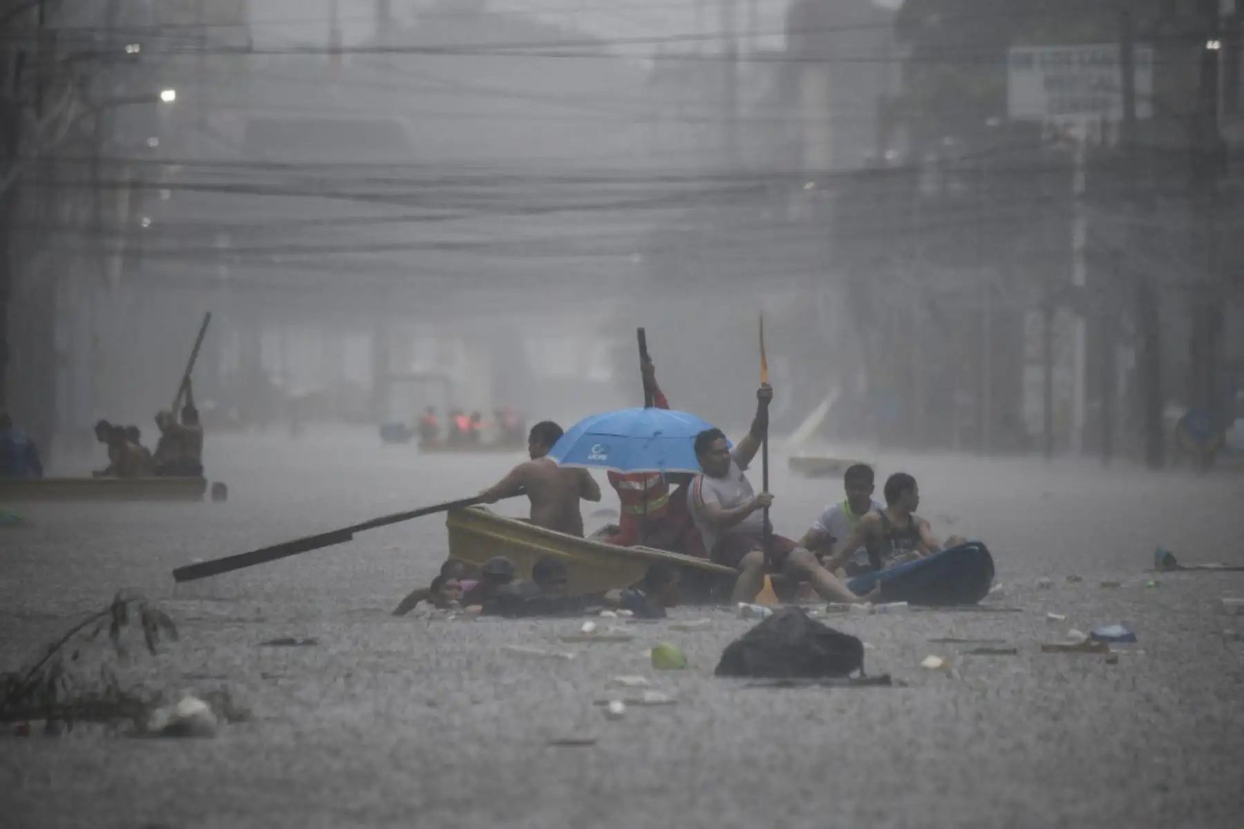 Los rescatistas reman en sus botes a lo largo de una calle inundada en Manila en medio de las fuertes lluvias provocadas por el tifón Gaemi. Foto: AFP