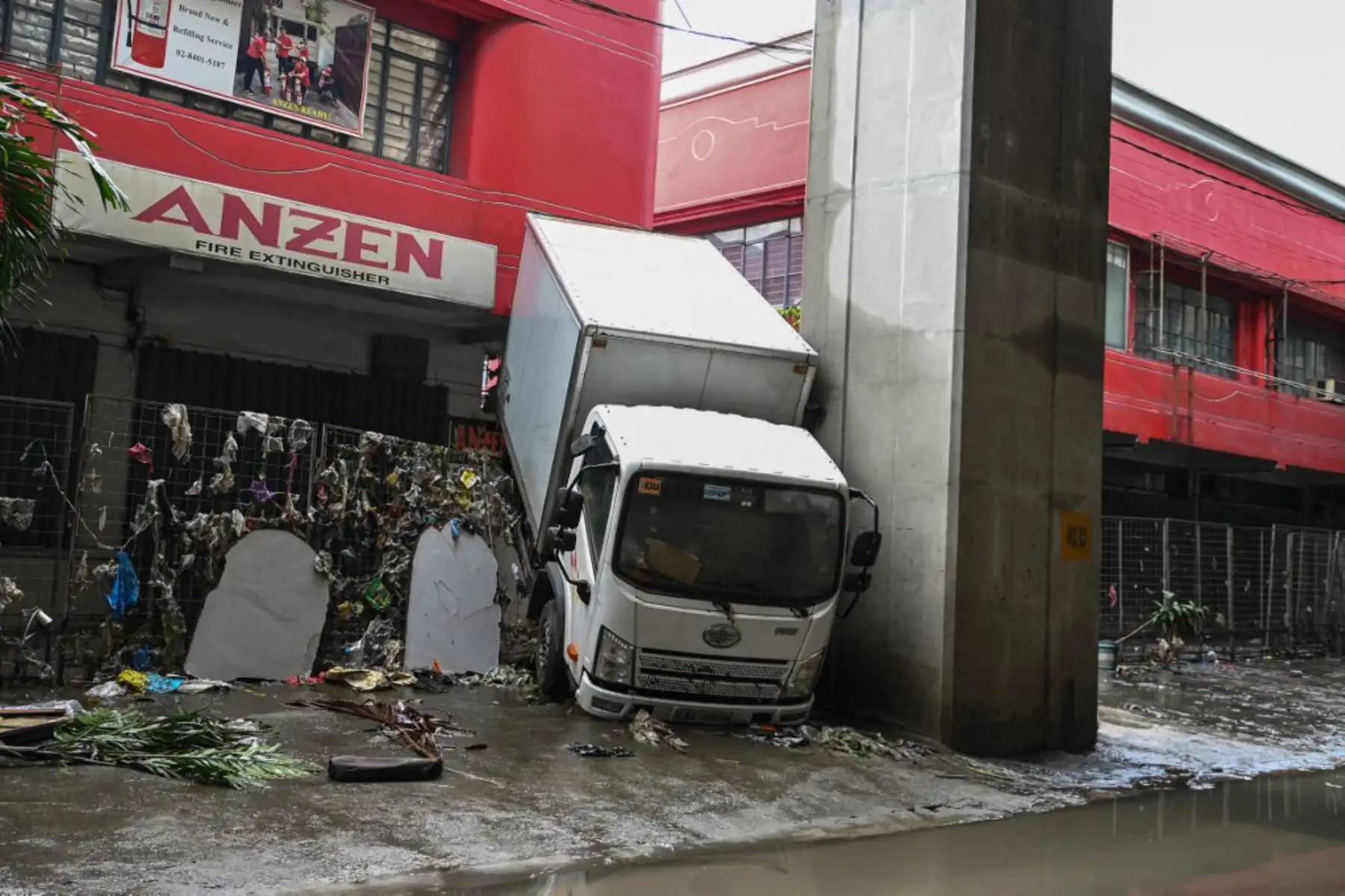 Un camión se ve atrapado en una valla tras el paso del tifón Gaemi en Manila el 25 de julio de 2024. Foto: AFP