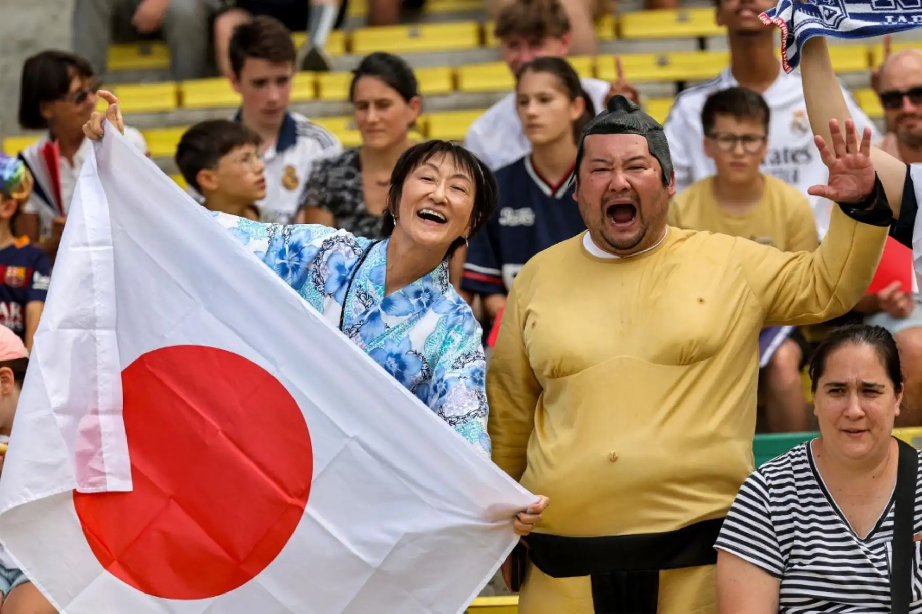 Aficionados japoneses, con un kimono tradicional y  con un traje de luchador de sumo, alientan a su equipo antes del partido de fútbol femenino del grupo C entre España y Japón durante los Juegos Olímpicos de París 2024 en el Estadio La Beaujoire en Nantes el 25 de julio de 2024. Foto: AFP