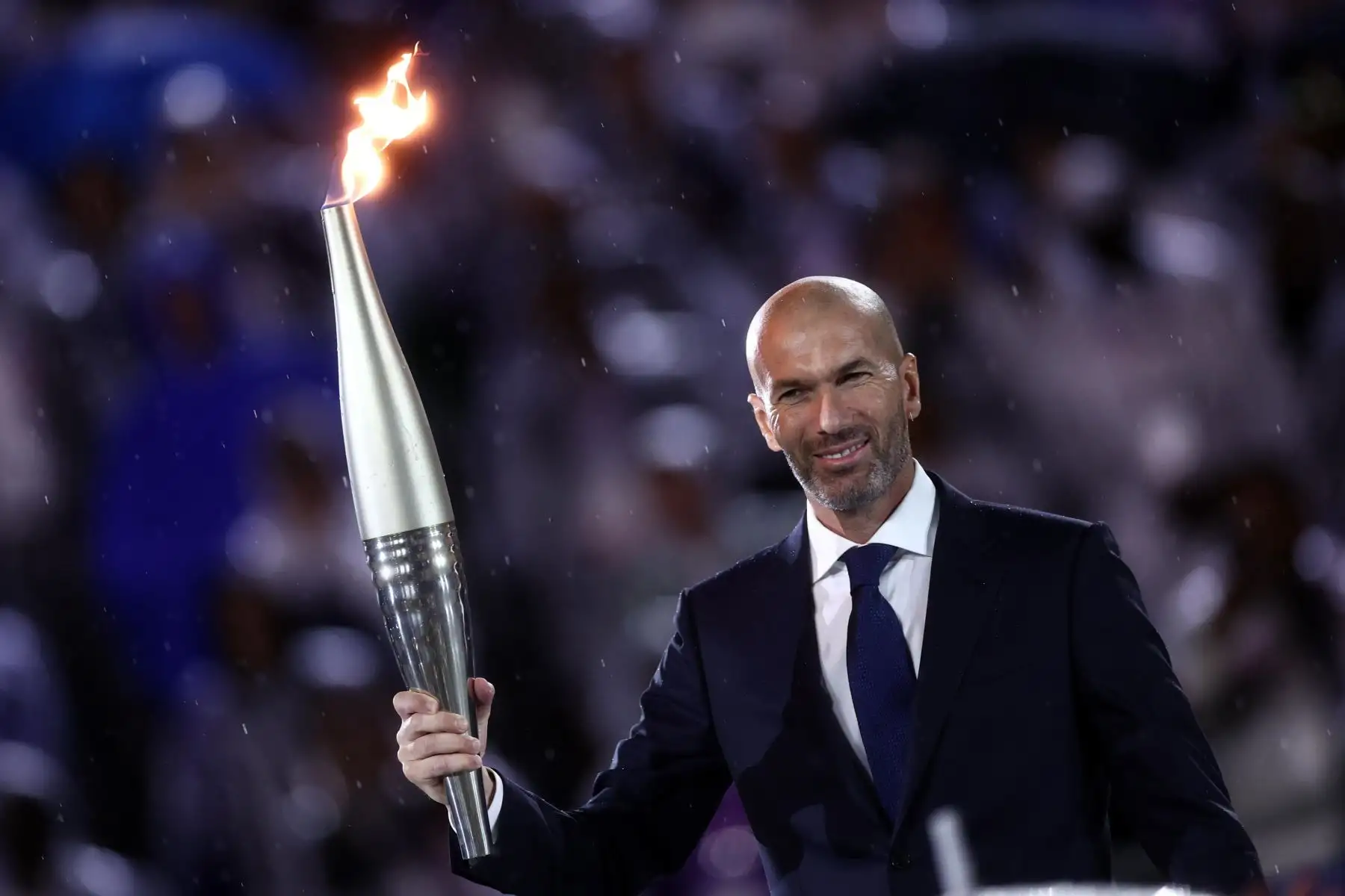 El exfutbolista francés Zinedine Zidane sostiene la antorcha olímpica durante la ceremonia de apertura de los Juegos Olímpicos de París 2024 en Francia el 26 de julio. Foto: EFE