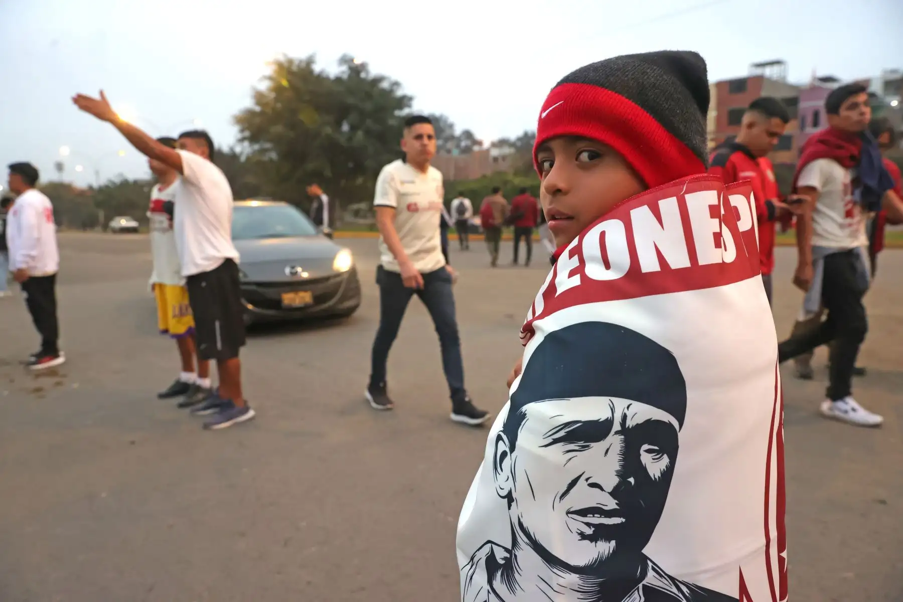 Hinchas de Universitario de Deportes alientan a su equipo en los exteriores del Estadio Monumental "U" de Ate momentos previos al clásico del fútbol peruano con Alianza Lima, partido por el Torneo Clausura de la Liga 1. Foto: ANDINA/Melina Mejía