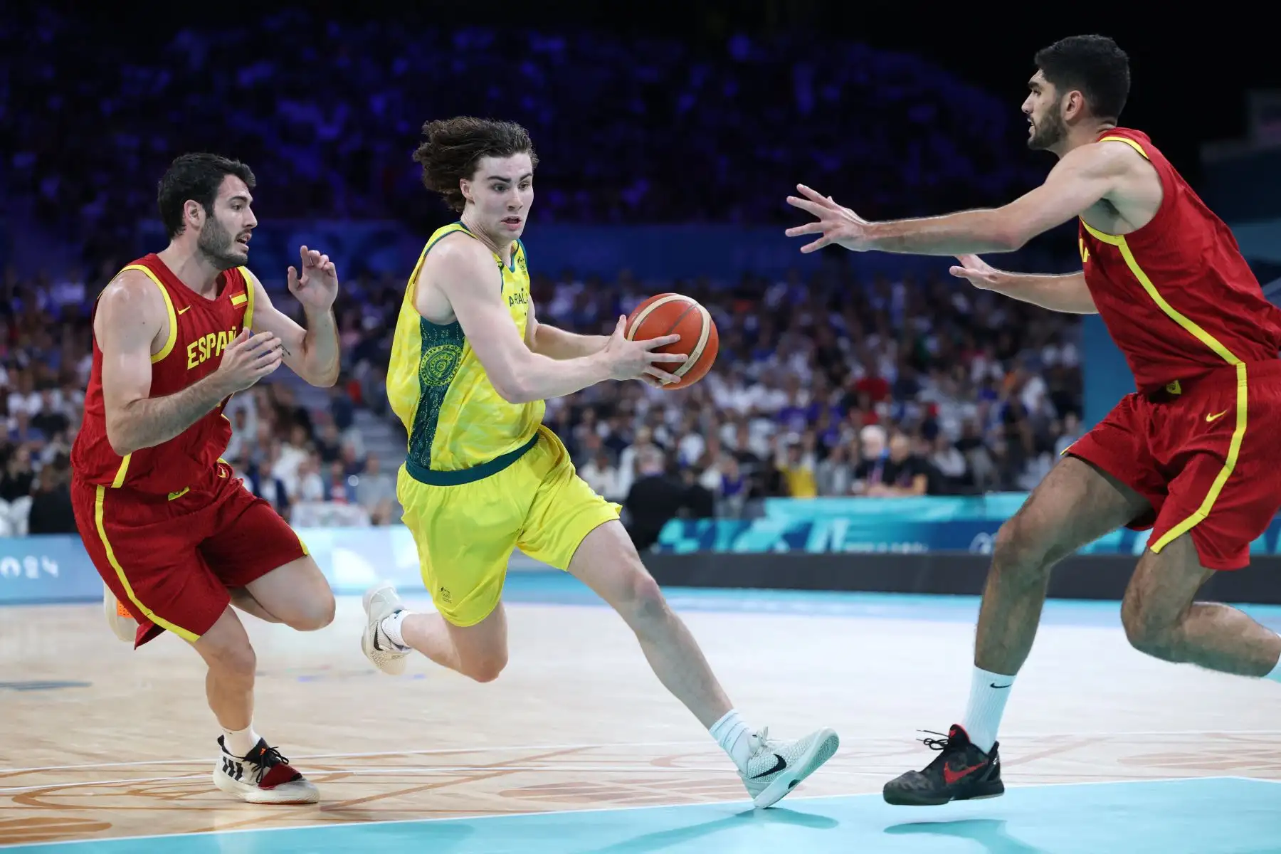 El australiano Josh Giddey desafía al español  Alex Abrines y al español  Santi Aldama en el partido de baloncesto del grupo A de la ronda preliminar masculina entre Australia y España durante los Juegos Olímpicos de París 2024. AFP